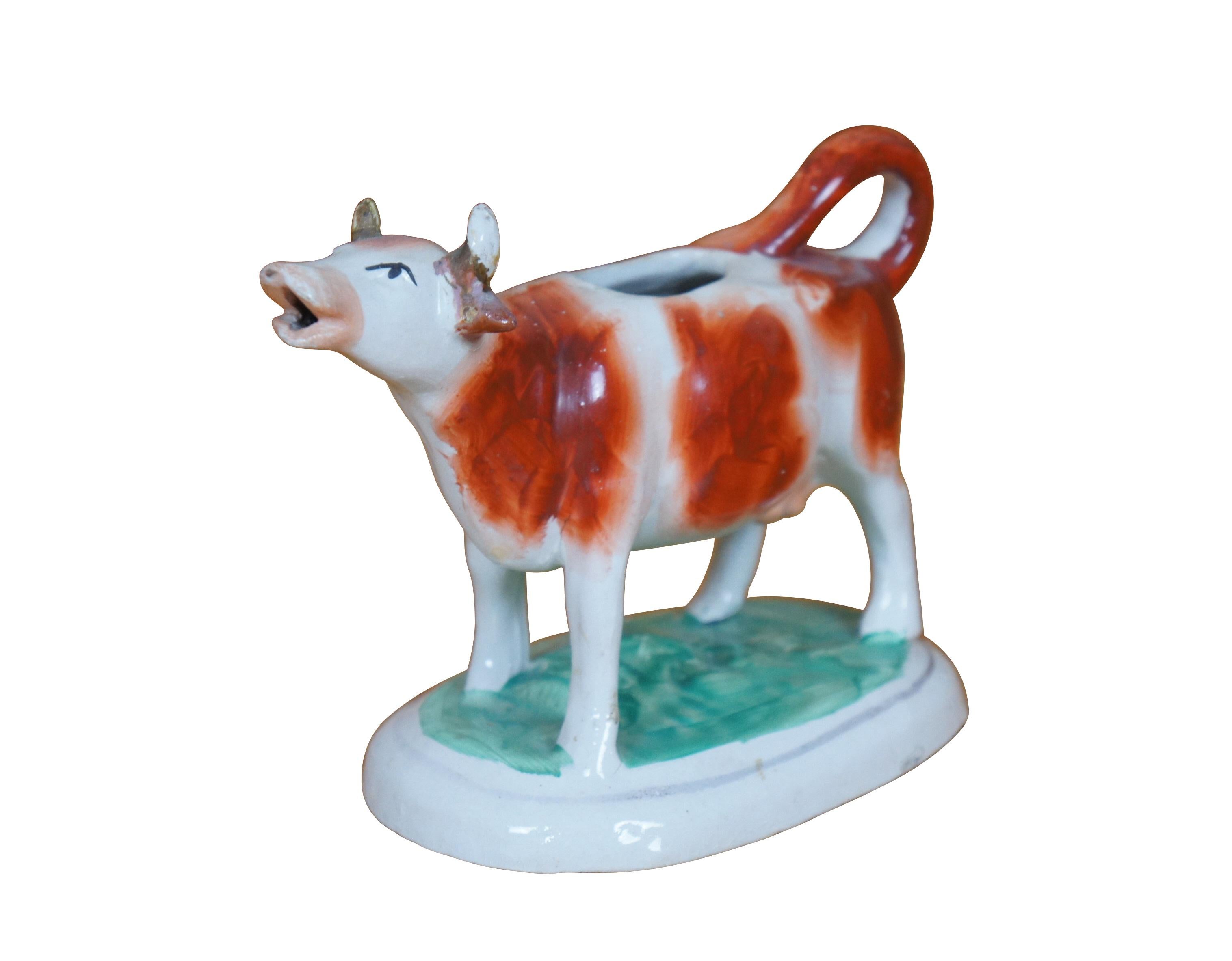 Antica brocca in porcellana Staffordshire del XIX secolo a forma di mucca rossa e bianca su una base ovale erbosa. Horn dorati. La coda si arriccia per formare il manico. Senza tappo.

Dimensioni:
6,75