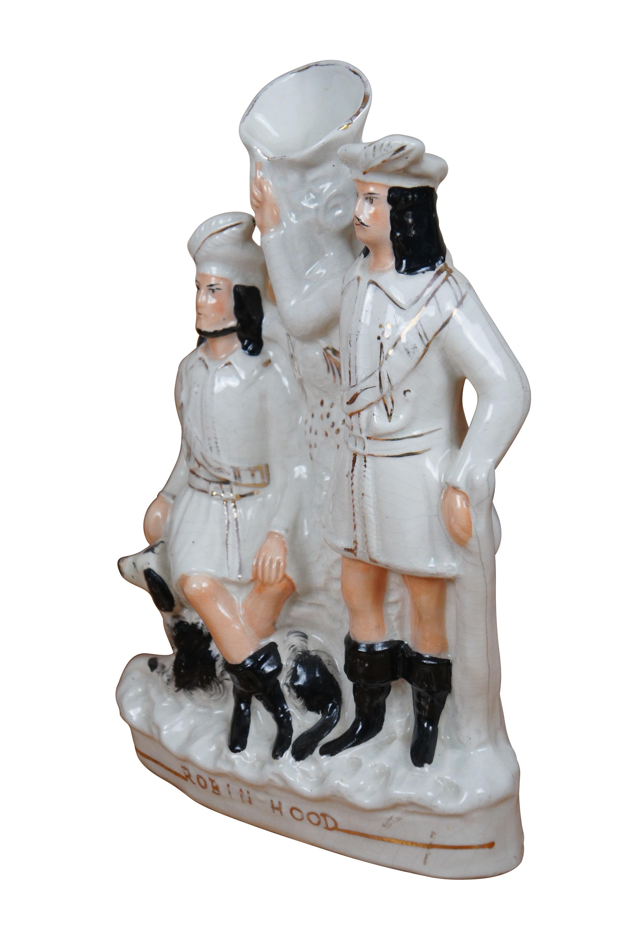 Antico vaso da versamento figurato in porcellana Staffordshire del XIX secolo, raffigurante il pettirosso Hood e Johns con un cane spaniel, in posa davanti a un ceppo d'albero decorato con pigne.

Dimensioni:
9