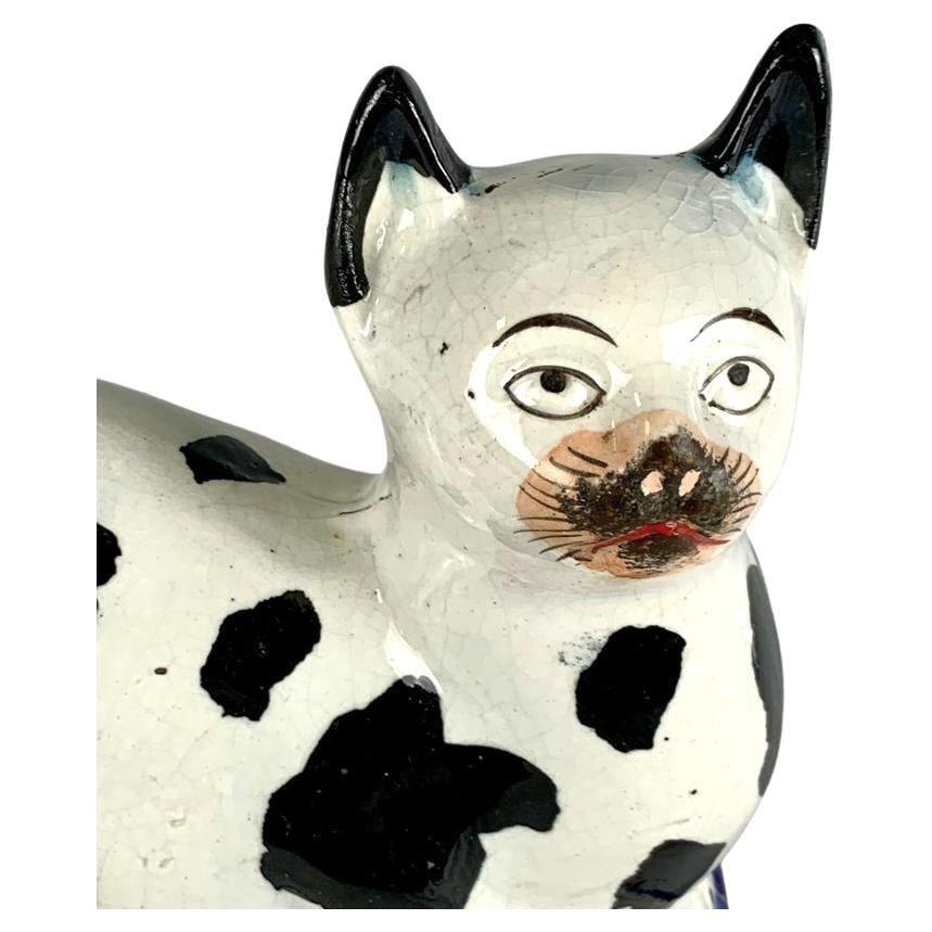 Diese schöne antike Staffordshire-Katze hat weißes Fell mit großen schwarzen Flecken.
Die um 1860 entstandene Katze ist mit handgemalter Glasur in Schwarz und Weiß verziert und ähnelt einer typischen Hauskatze.
Abmessungen: 5,75' hoch x 5,75