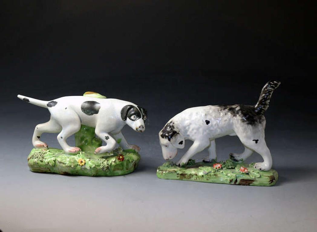 A pair of antique Staffordshire pearlware pottery pointer and setter dogs. The pair are good examples with good modeling and enamel decoration.