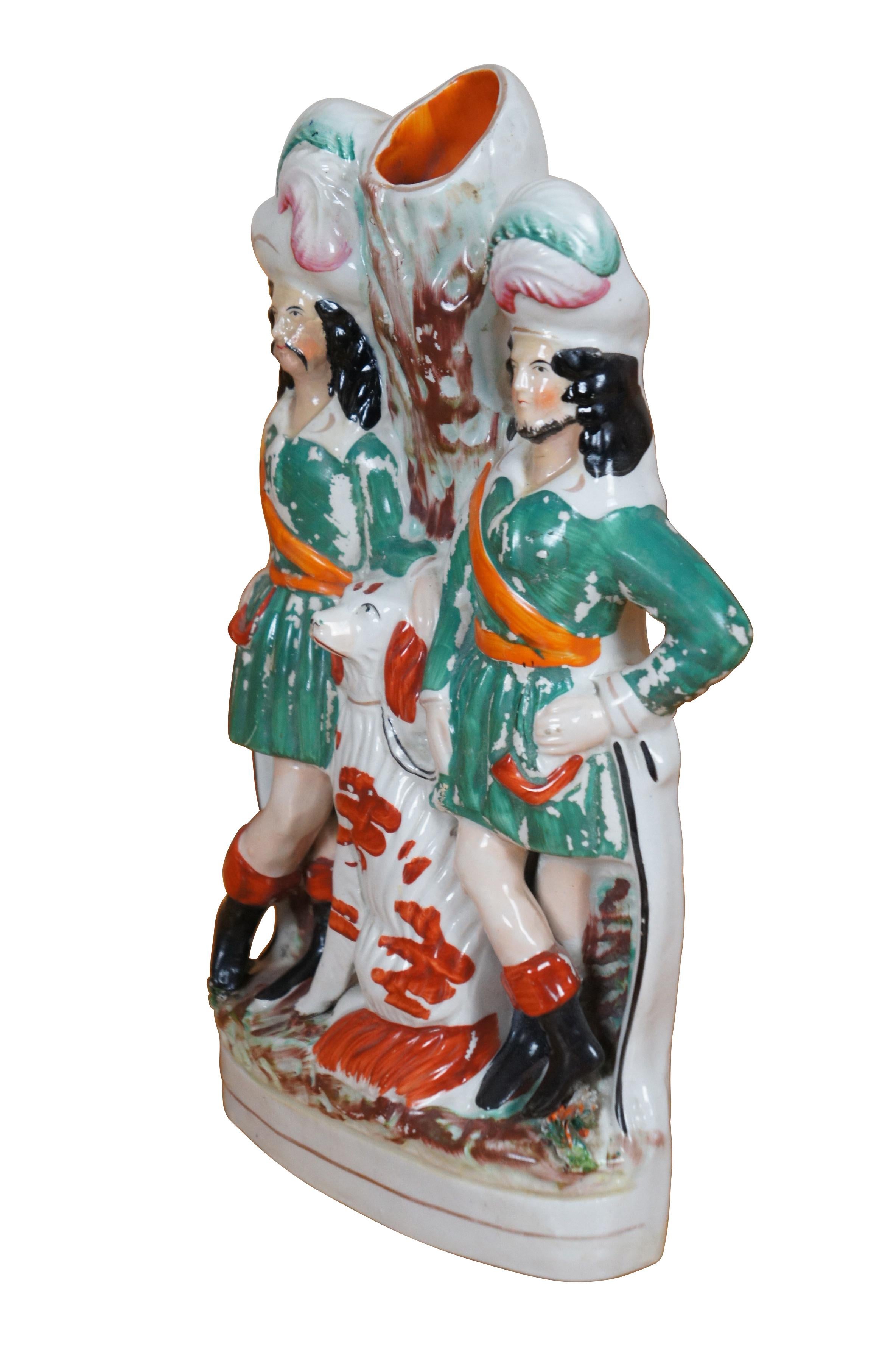 Antico vaso da versamento figurato in porcellana Staffordshire del XIX secolo che raffigura l'eroe folcloristico Robin Hood e I. Johns vestiti di verde e arancione con corna da caccia, affiancati da un grande cane spaniel rosso e bianco davanti a un