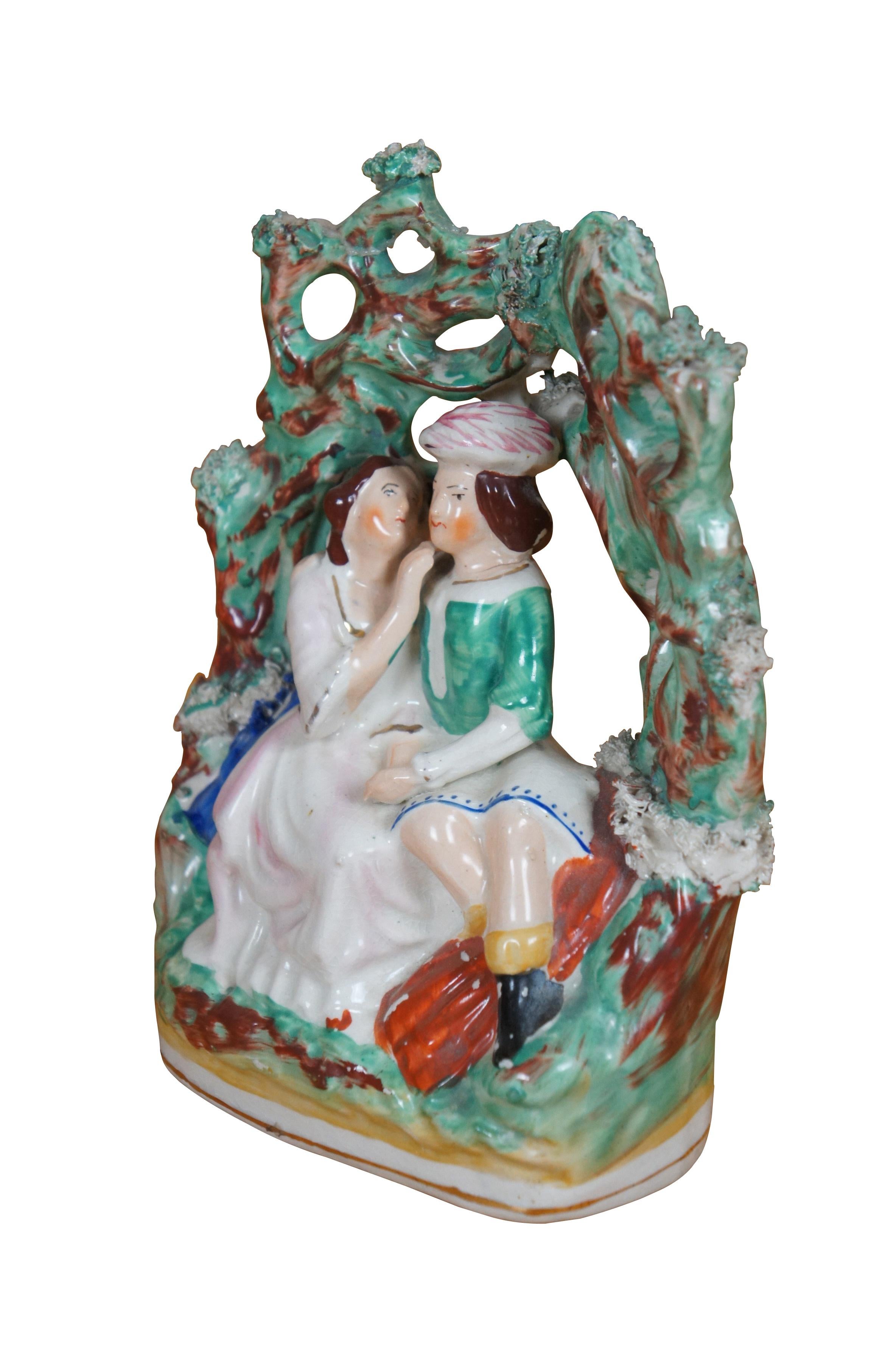 Ancienne figurine à dos plat en porcelaine du Staffordshire du XIXe siècle représentant un couple d'amoureux / couple de courtisans - Roméo et Juliette de Shakespeare - assis sous une Bower / tonnelle / arbre de jardin vert.

Dimensions :
6,5