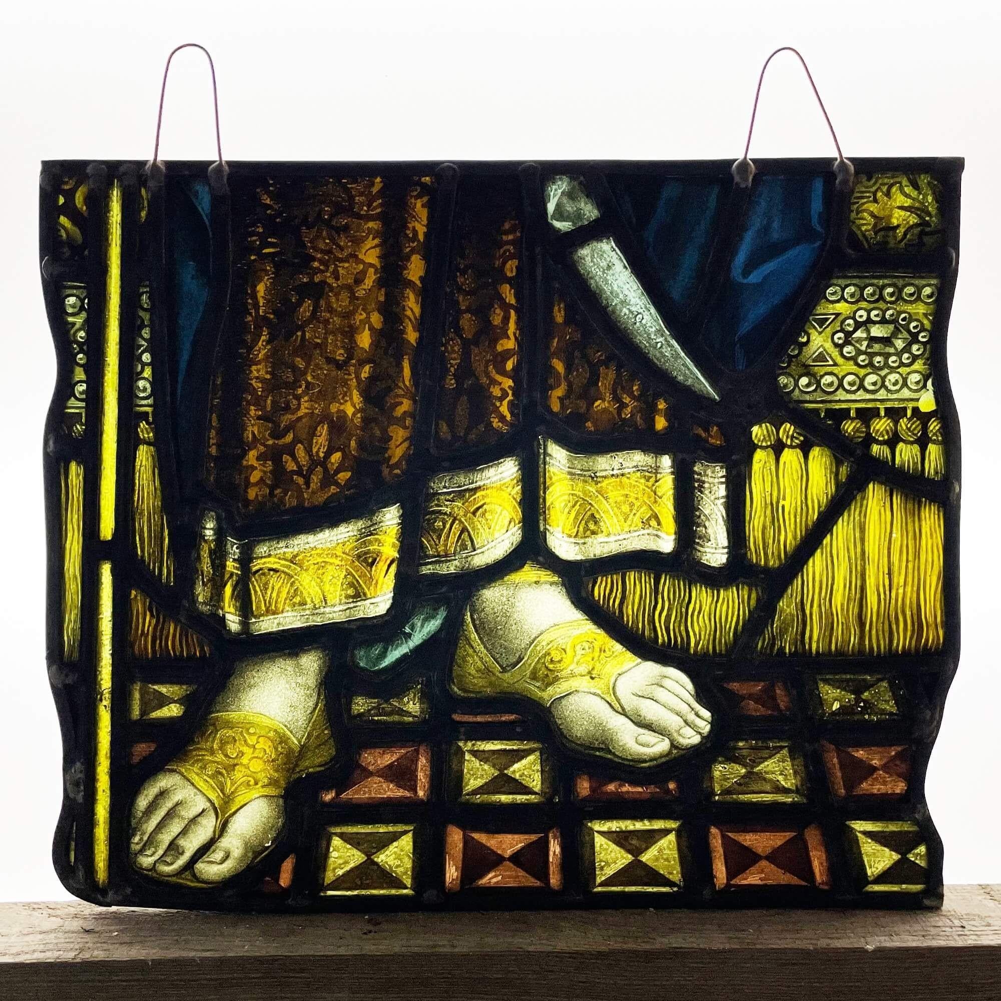 An antique stained glass window depicting the feet of a nobleman’s feet, dating to circa 1850. This English stained glass panel showcases a well painted vivid image of the nobleman’s feet in classical sandals from underneath his long patterned robe.