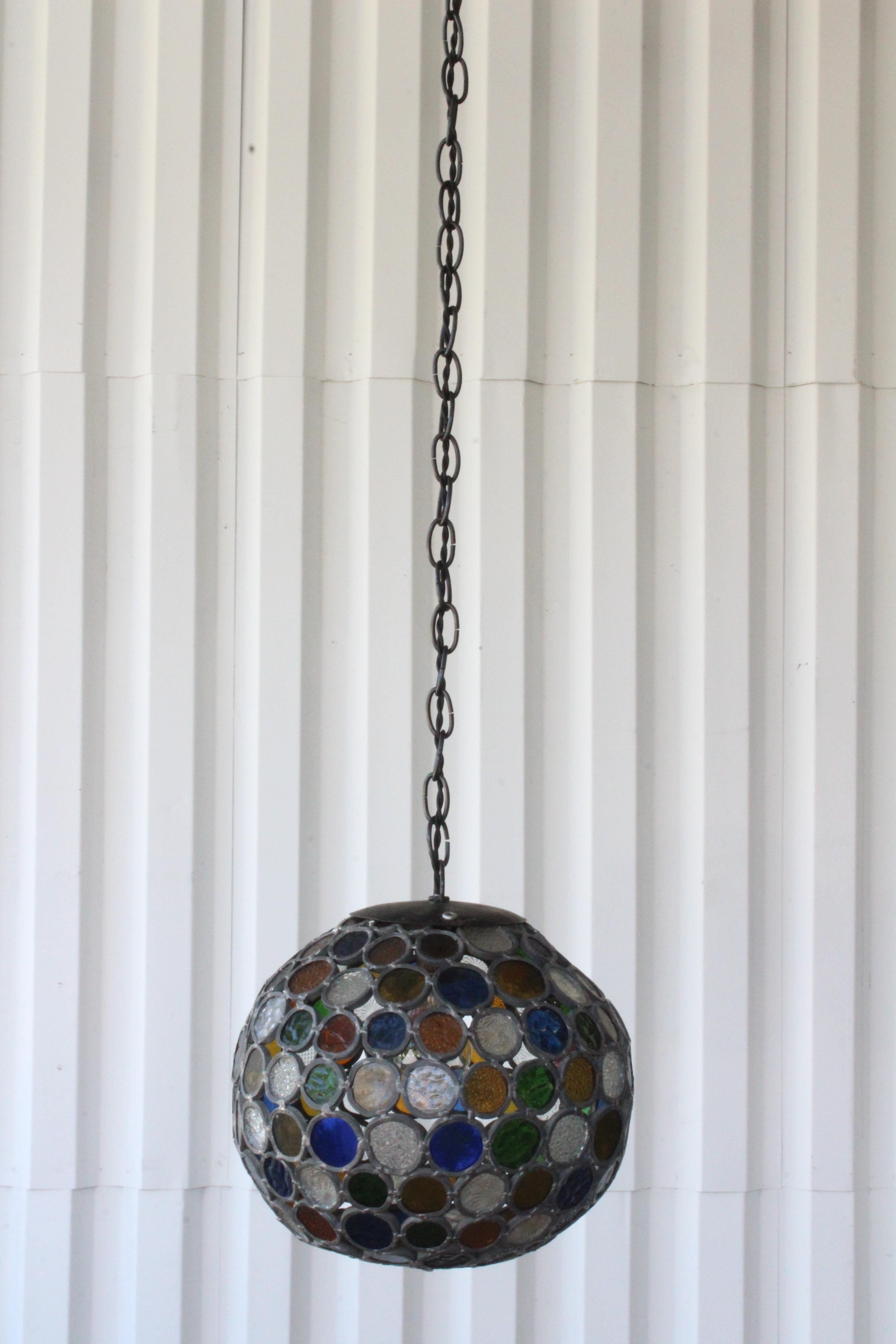 Beautiful one-of-a-kind hanging pendant light. Made of leaded stained glass in various colors, welded together to form a unique hanging fixture. Newly rewired. Uses one standard light bulb. Total height with chain is 50 inches. The fixture itself is