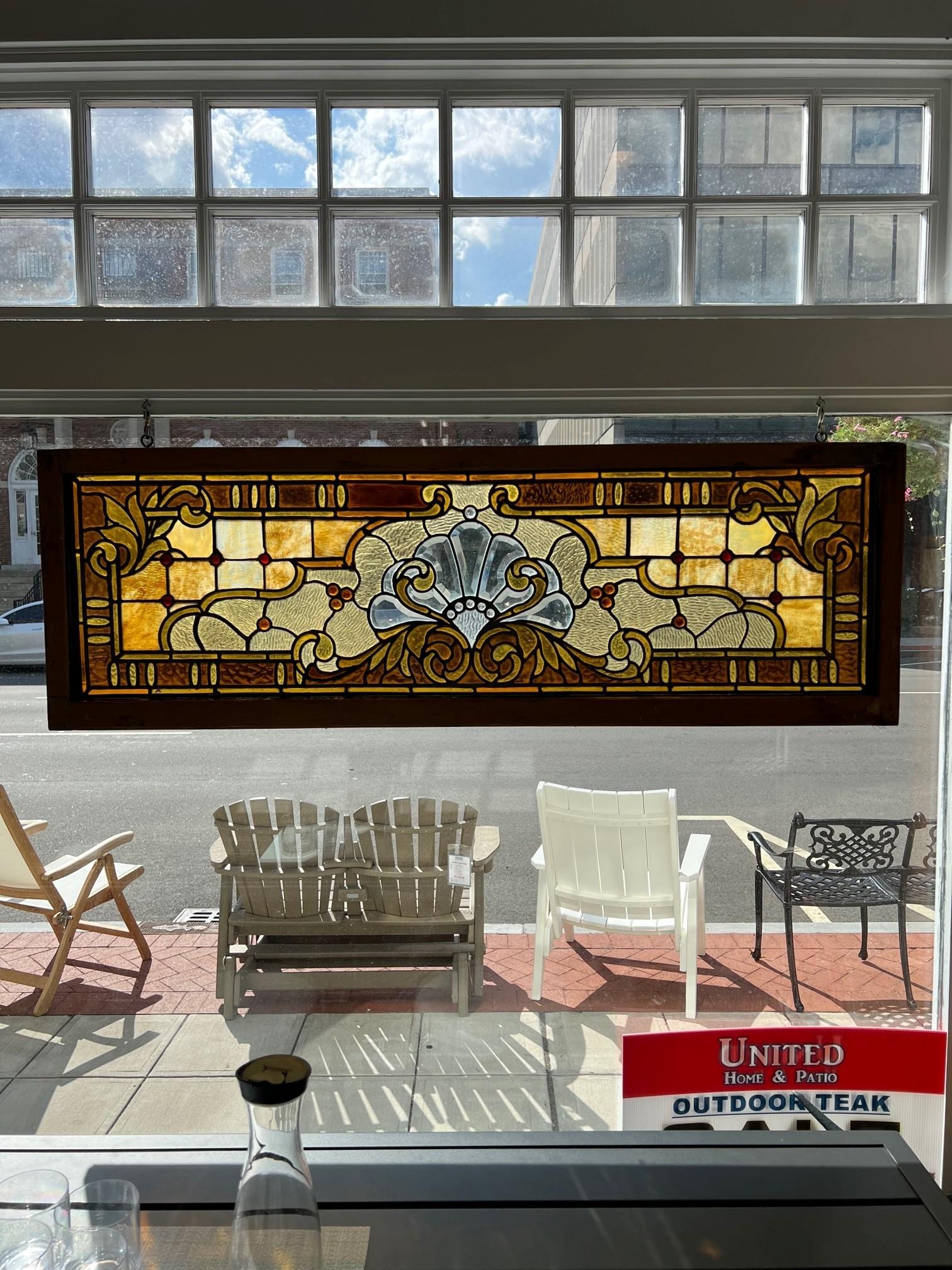 Late 19th century stained glass transom window with jewels and a beveled glass center in the original frame. Salvaged from an estate in Philadelphia PA. this window would look great hanging in any room with great colors and beveled center. There are