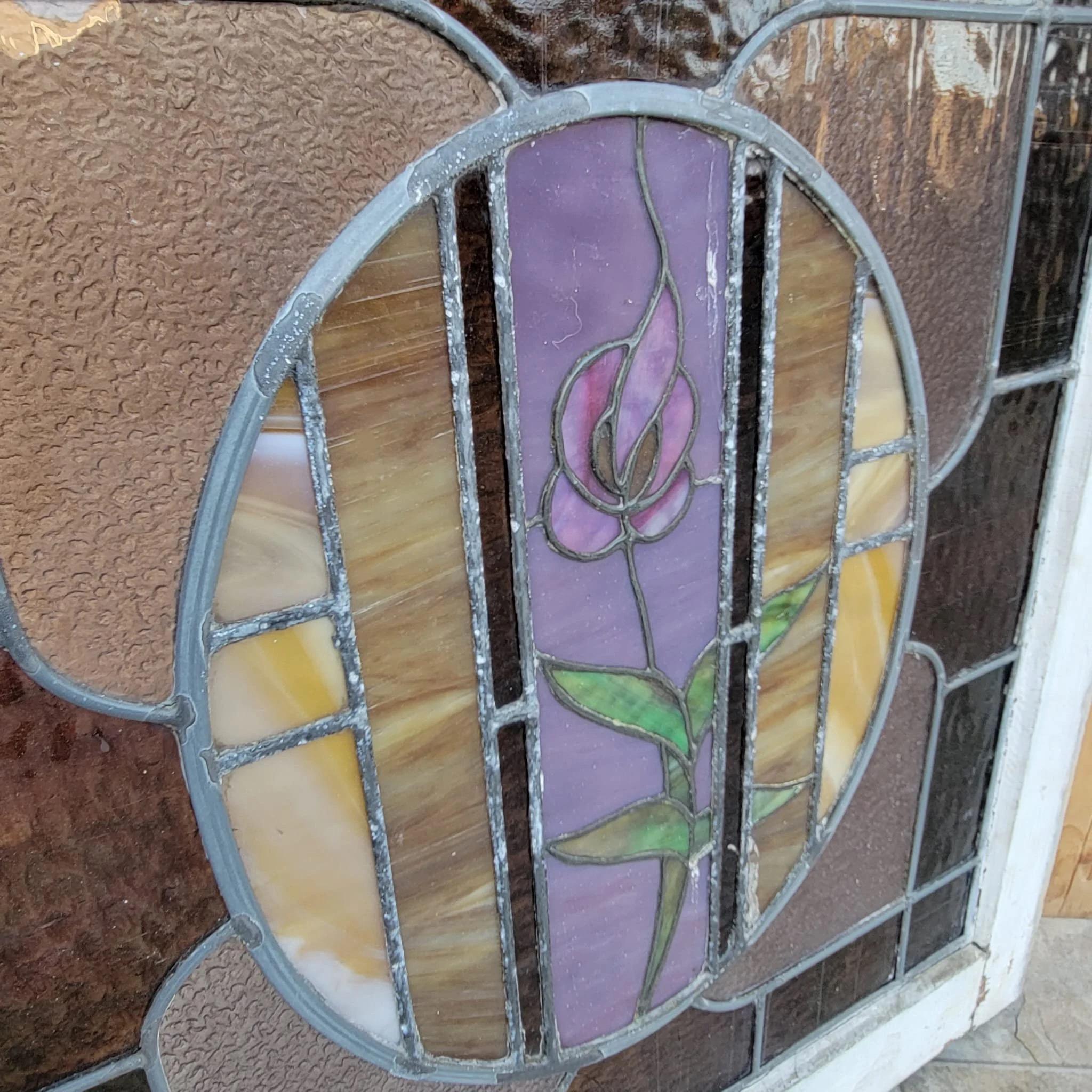 Antique Stained Glass Window 

Create a floral atmosphere in your bathroom with the soft rosey light of this stained glass window. The pane depicts a lovely violet framed by a mandorla, surrounded by dark pink frosted glass. A white, rustic frame