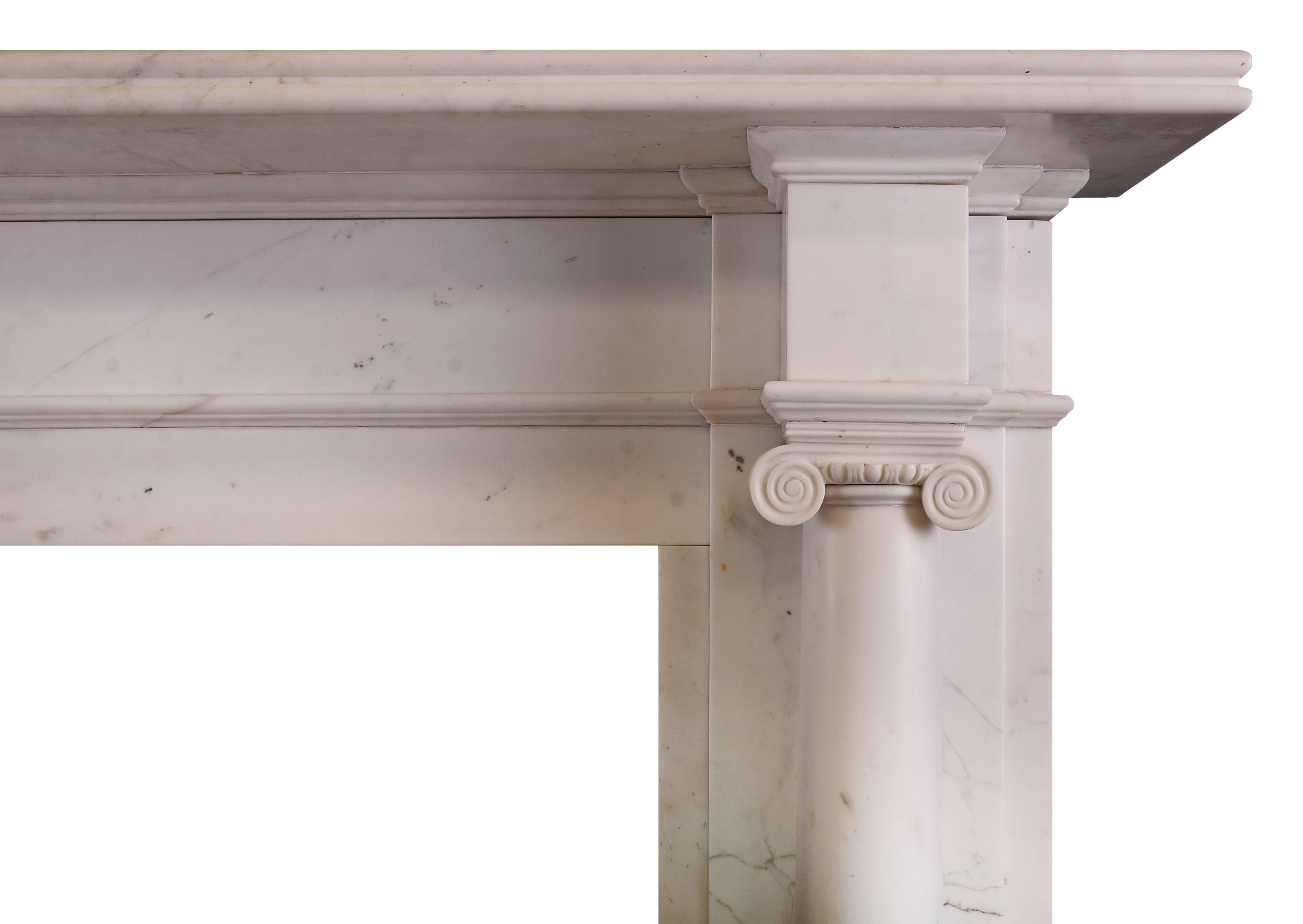 A 19th century English statuary marble fireplace in the Georgian manner. The full round columns, surmounted by Ionic capitals, plain frieze and double reeded shelf. A well proportioned piece.

Measurements:
Shelf Width: 1800 mm / 70 7/8 in
Overall