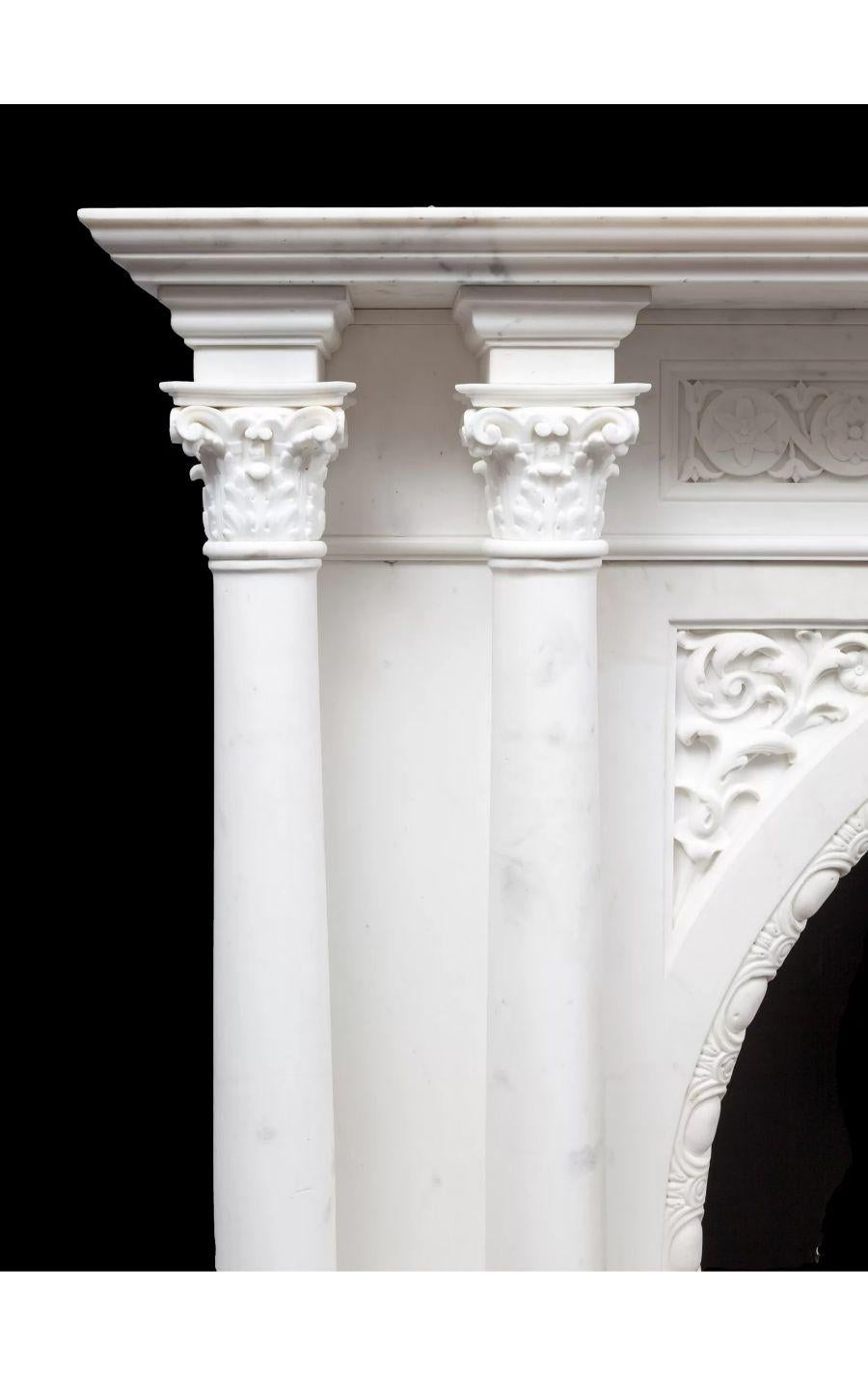 A large and grand antique Statuary marble fireplace dating to the 1850’s.

Each pilaster with two full rounded and free standing Corinthian columns that support a substantial mantel shelf. The arched opening carved with egg and dart moulding, this