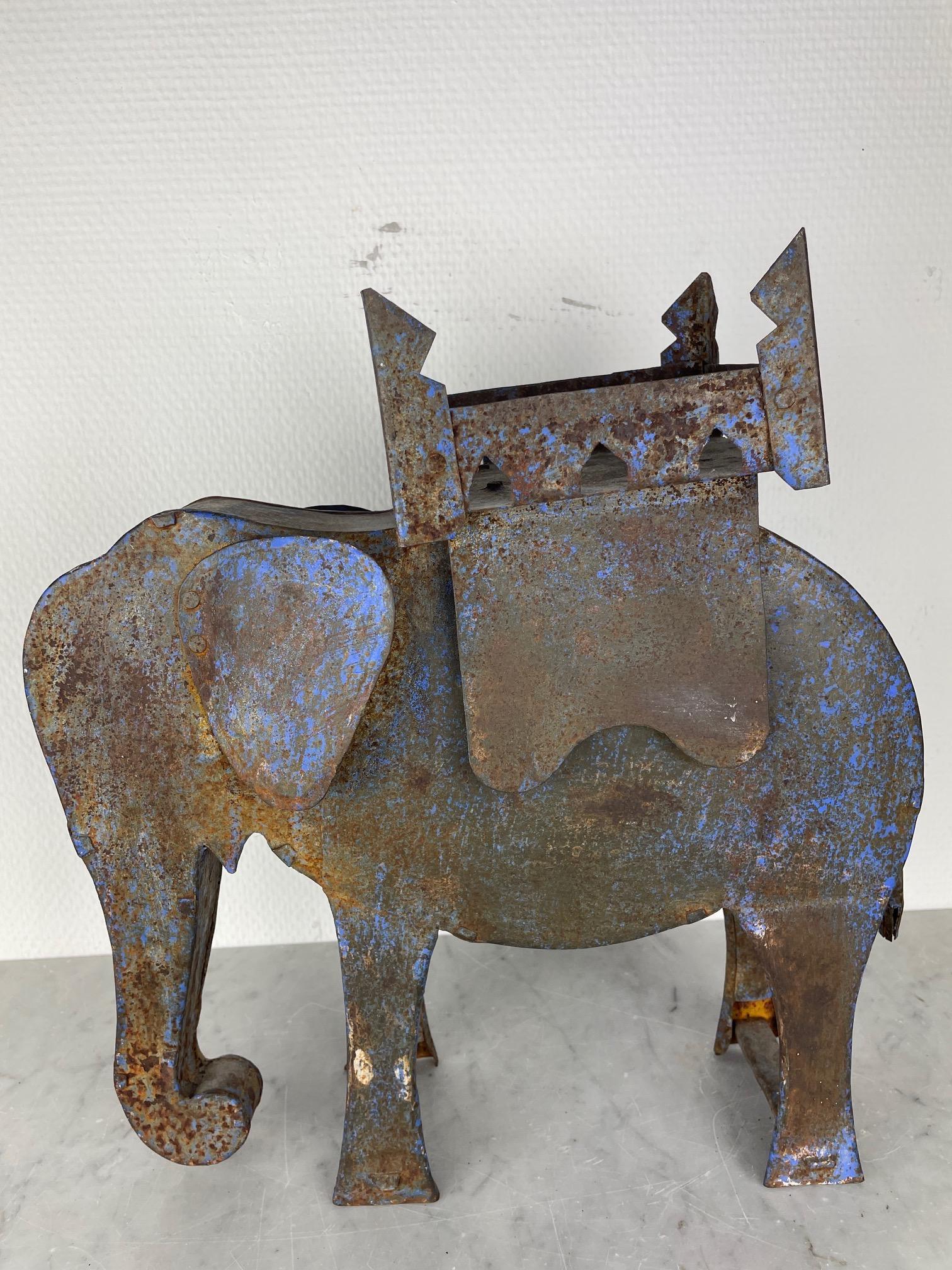This steel Elephant is a stunning piece. This is an item you just want to own and place in your home, bar or shop. It is hand made in most probably India in the late 1920's. It used to be blue but now has a beautiful patina on it. This piece of arts