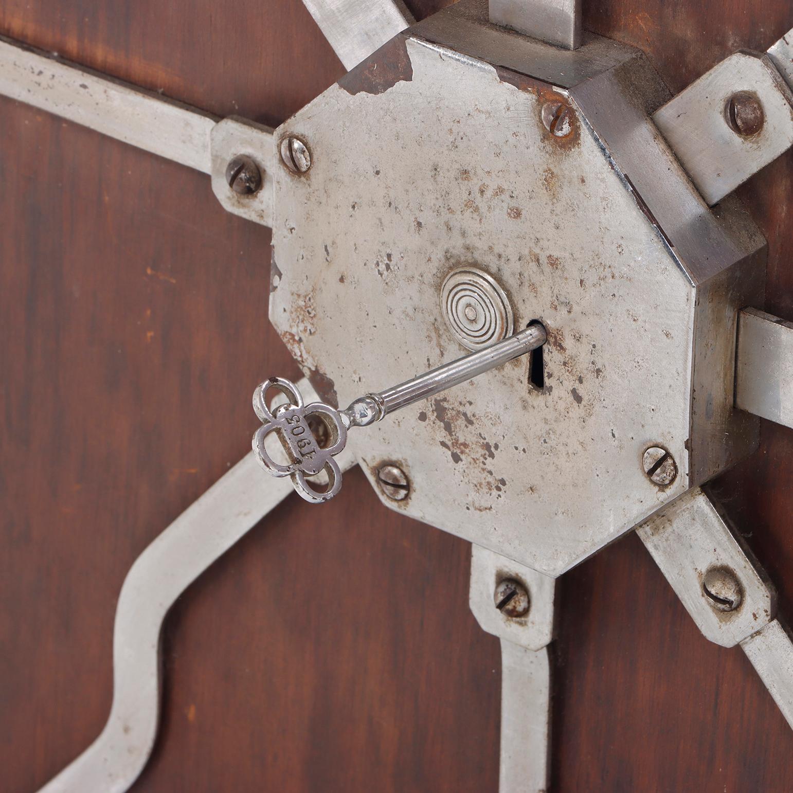 Mecanismo de cerradura de acero antiguo montado sobre un tablero de madera. Acero en venta