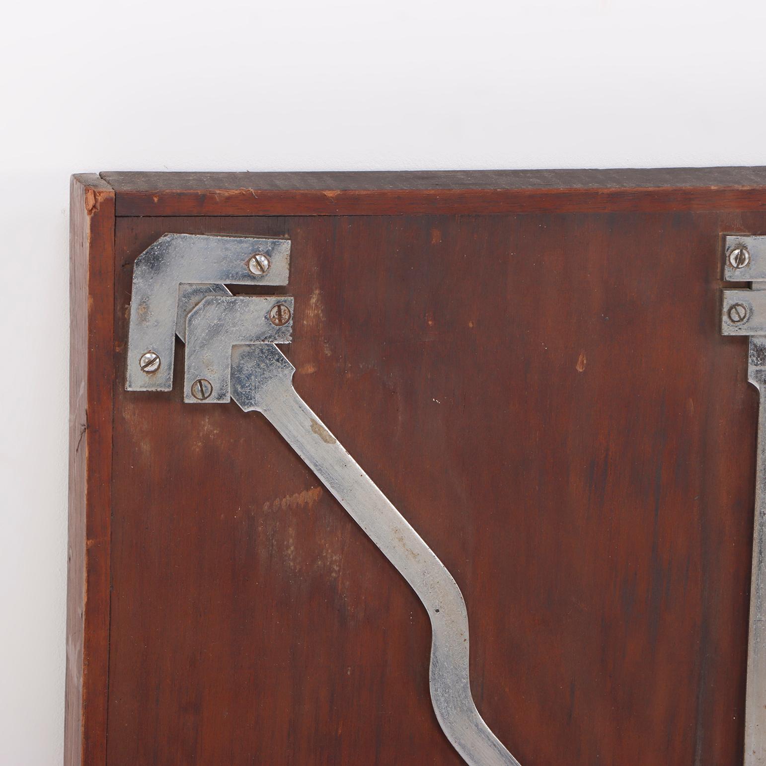 Mecanismo de cerradura de acero antiguo montado sobre un tablero de madera. en venta 1