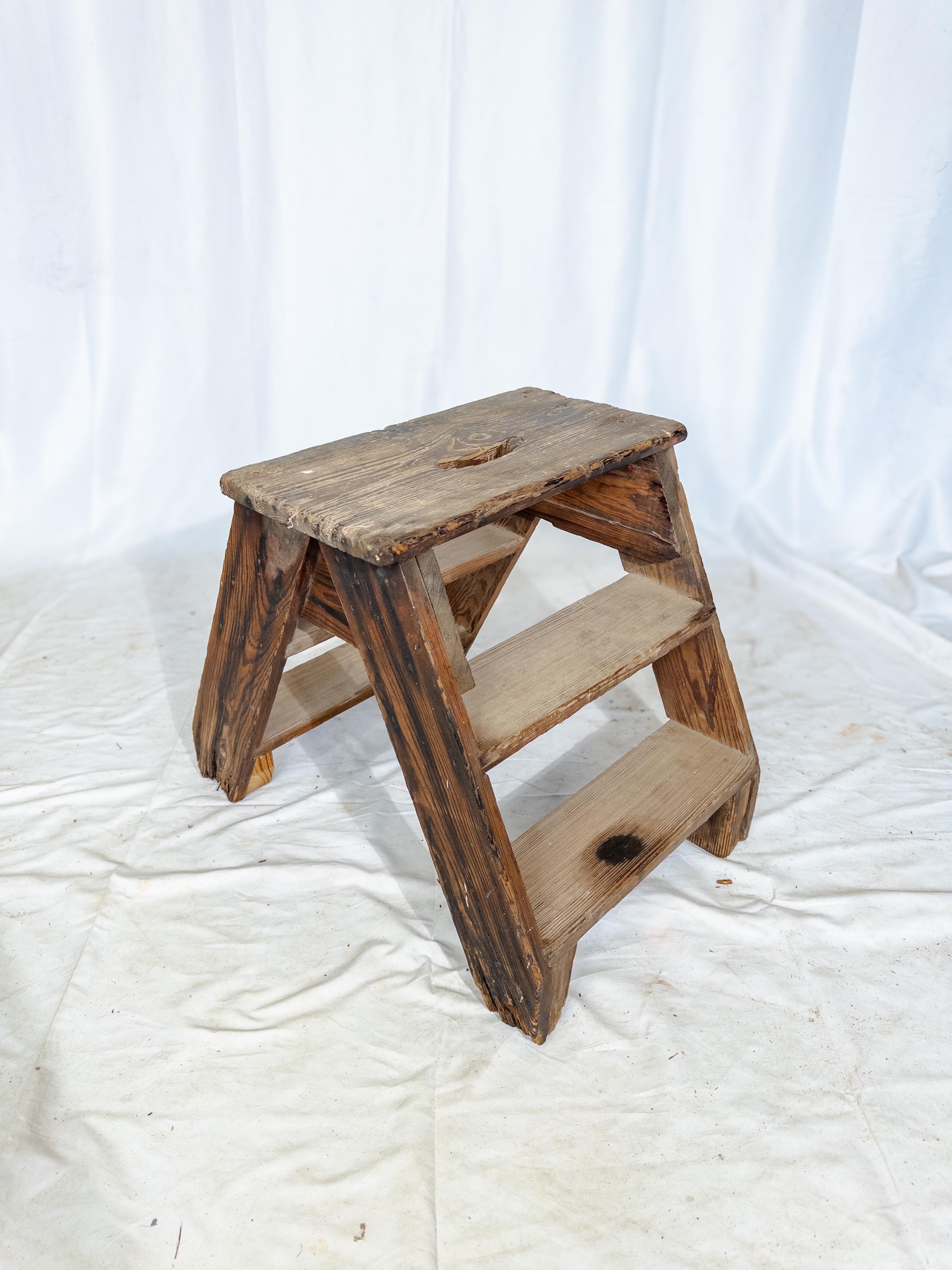 This antique step stool hails from the rugged shores of New England, embodying the enduring craftsmanship of the region. Carved from sturdy wood, it stands as a humble yet essential piece of household furniture, reflecting the practical