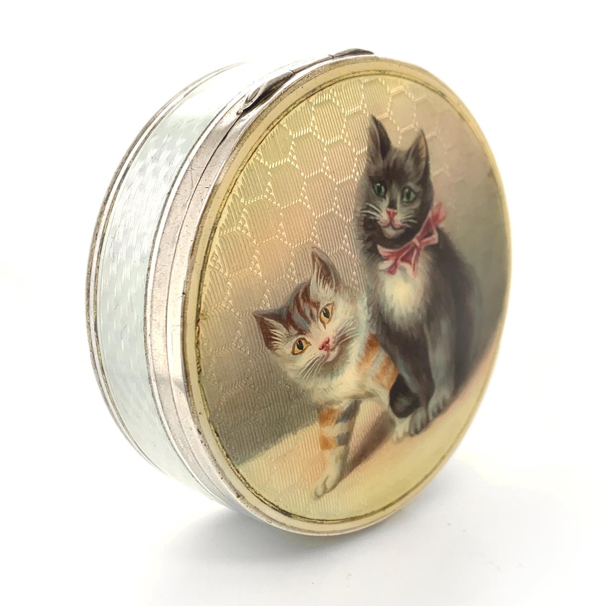 Most endearing kitten case:  a round  sterling silver hinged box with two adorable enameled kittens.  One is black and white with a big pink bow and the other has orange and white stripes. The top of the case is guilloche enamel, with a golden