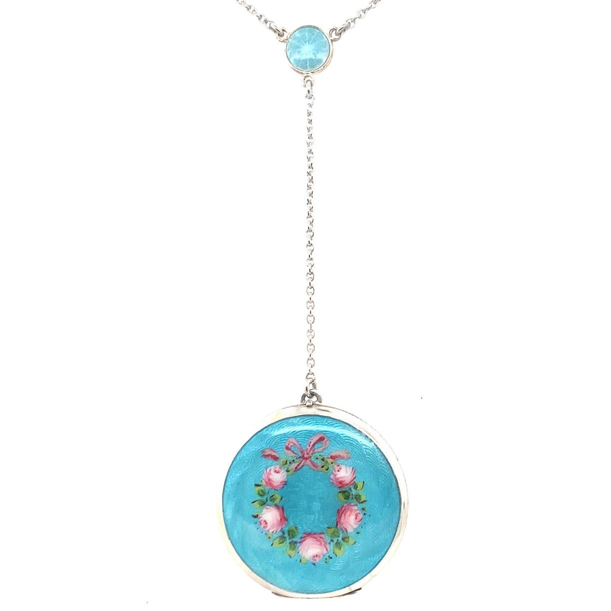 Absolutely beautiful sterling silver locket and original chain.  The round locket opens to reveal space for two pictures; original bezels are intact.  The locket is a rich turquoise guilloche enamel, embellished with a circle of pink roses.   The