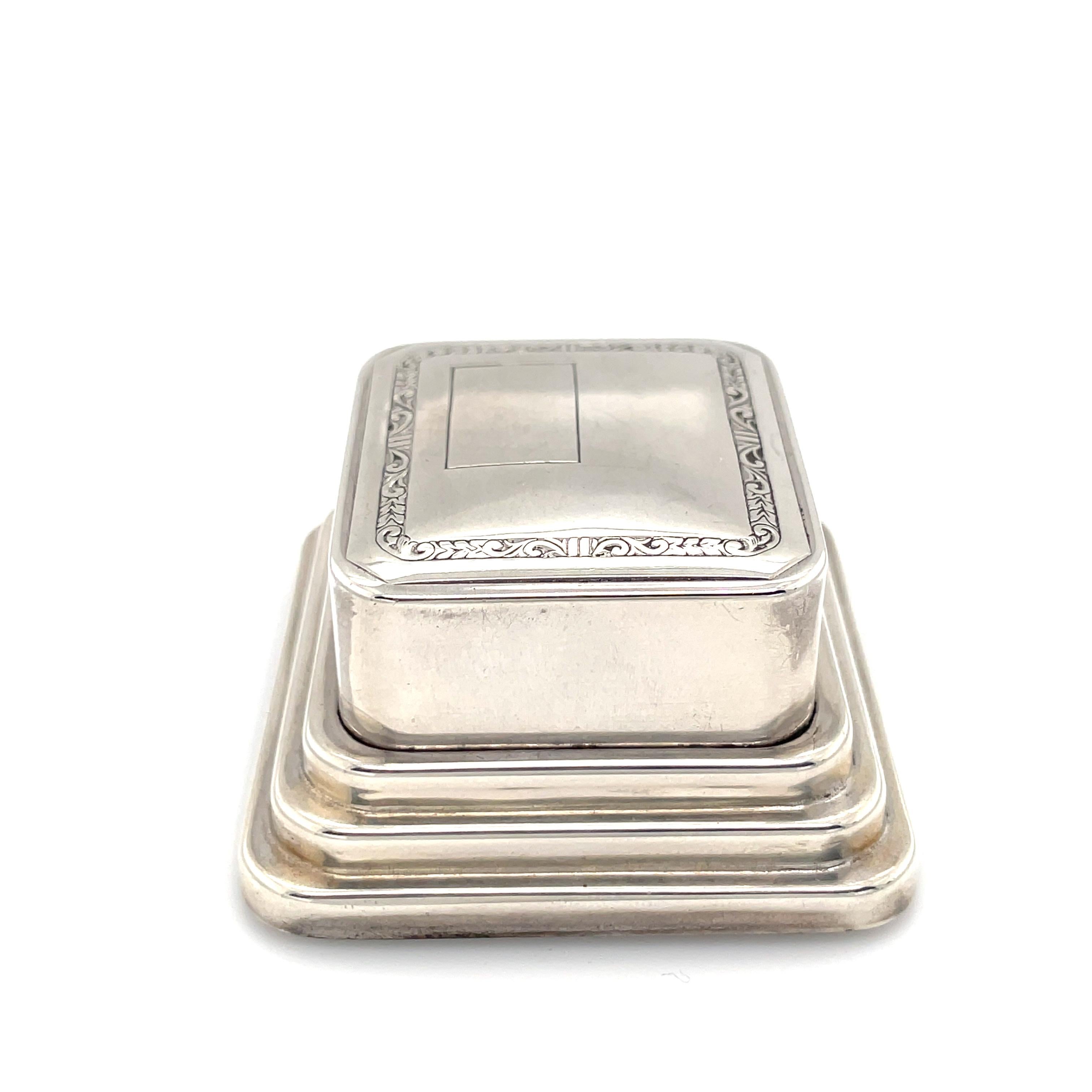 Antique sterling silver hinged ring box.  Distinctively set on three graduated sterling pedestals.  There is an engraved border on the top, along with a reserve for hand engraving a monogram.  Overall size is 2