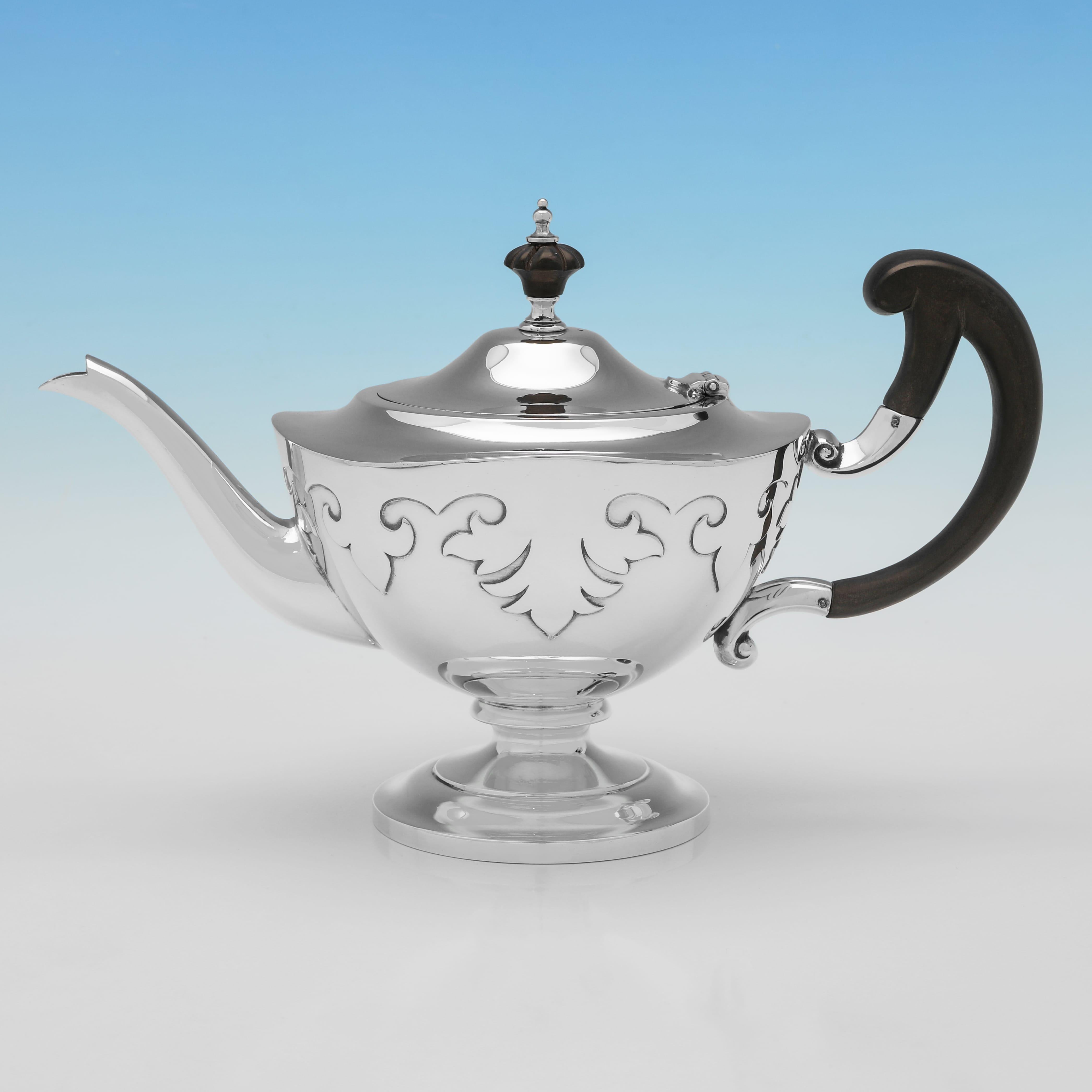 This exquisite sterling silver three-piece tea set, hallmarked in Sheffield in 1917 by the distinguished Walker & Hall, showcases elegant proportions and fine cut card decoration—a rare and refined technique where shaped appliqués are meticulously