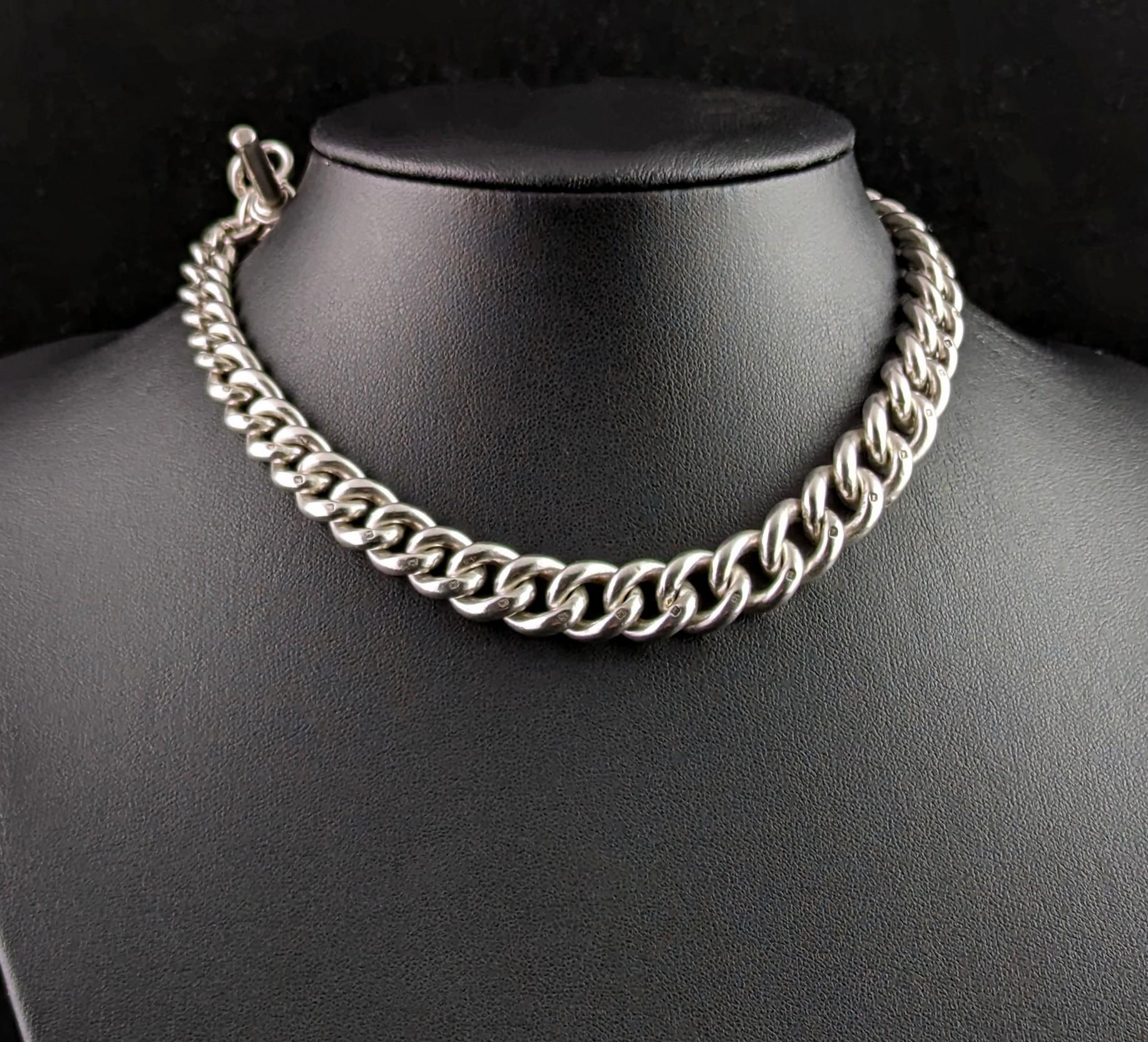 You can't help but fall in love with this handsome antique Albert chain.

It is a sterling silver chain with a chunky and heavy graduating curb link with a base metal dog clip fastener to one end and a T bar and short chain length to the