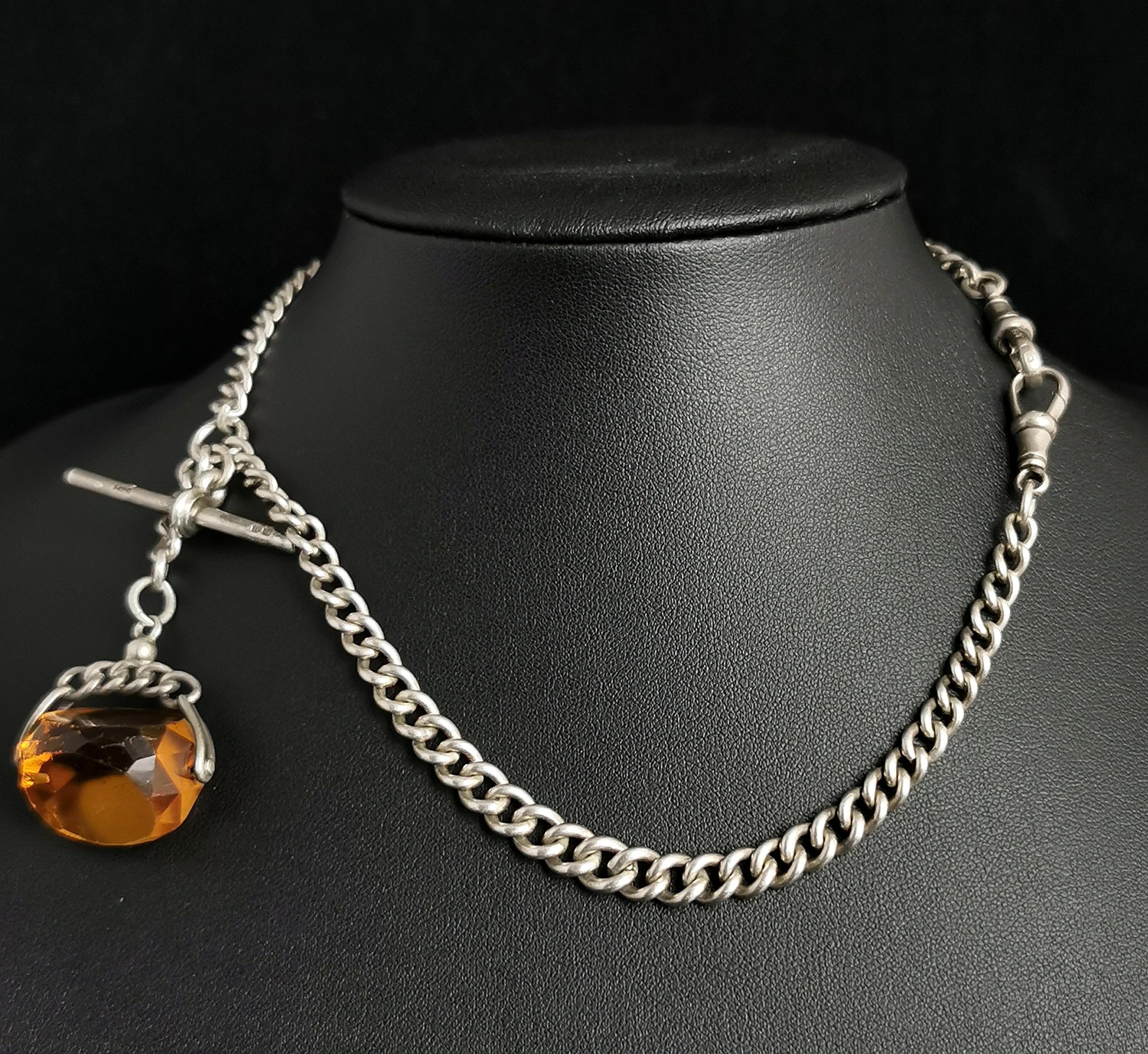 An attractive antique, Art Deco era Albert chain.

It is a sterling silver chain, graduating curb link with two dog clip fasteners either end, a T bar and a citrine spinning fob.

The fob has a sterling silver mount and a rich deep yellow faceted