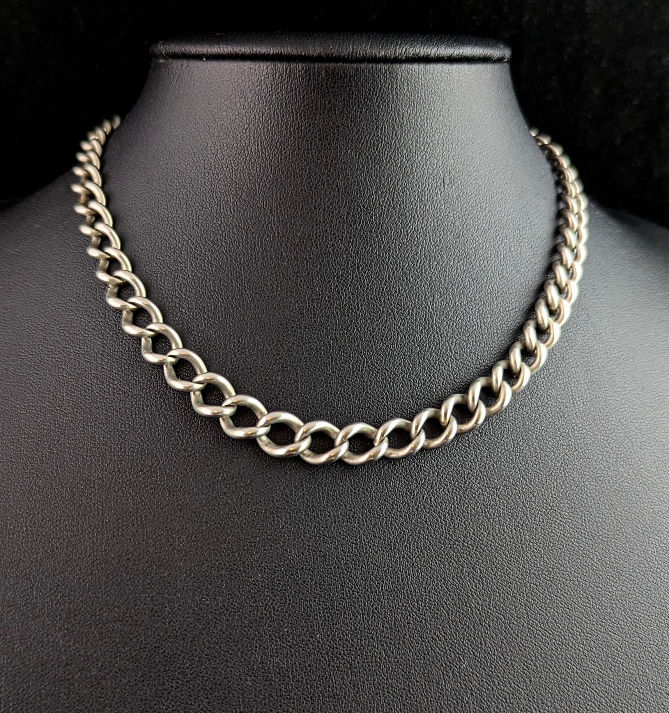 Une jolie chaîne Albert ou chaîne de montre ancienne en argent sterling de l'époque édouardienne.

Jolis maillons en argent massif, gradués et ouverts, avec une attache pour chien à une extrémité et un grand anneau de saut de l'autre côté.

La