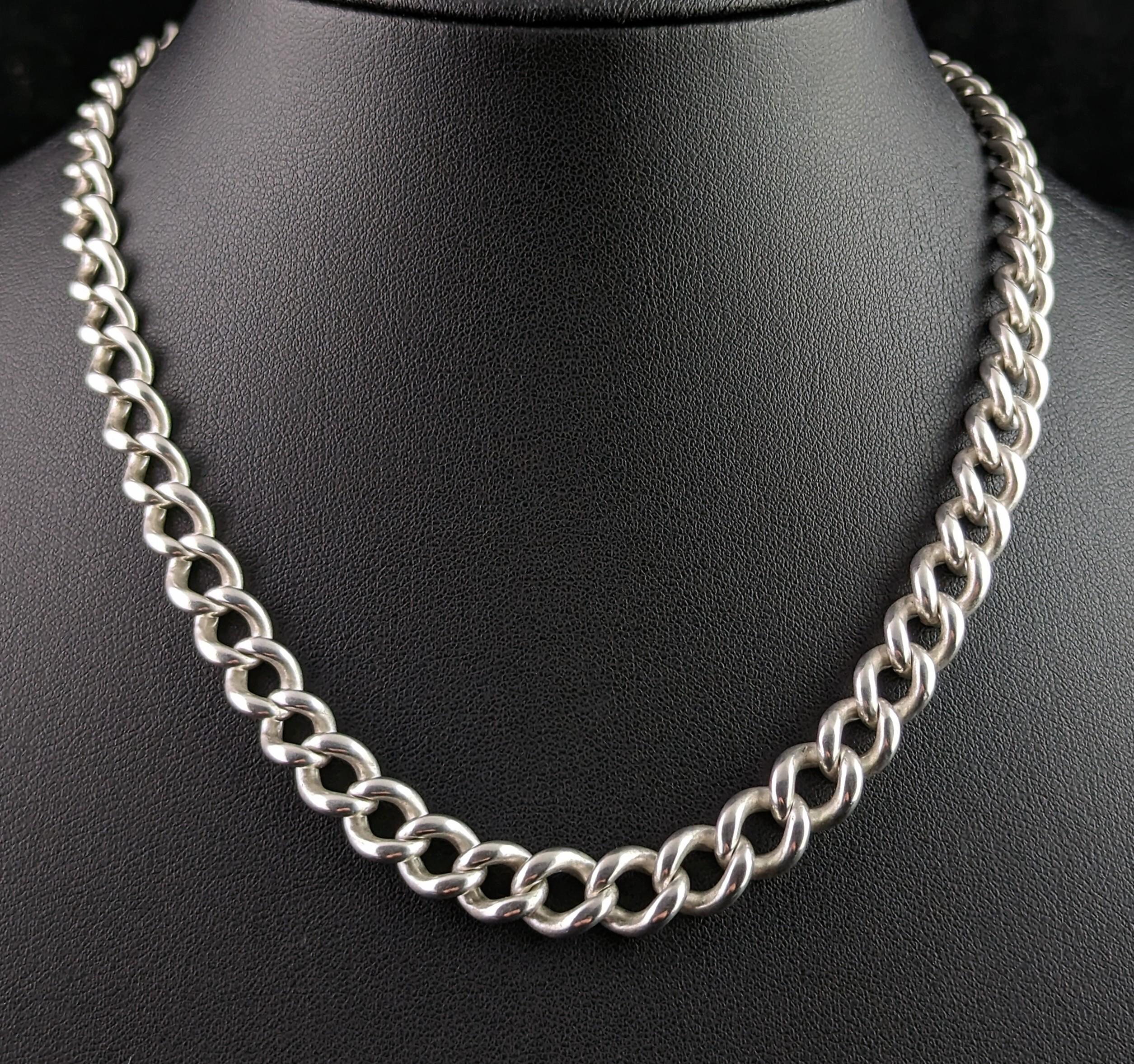 You can't help but fall in love with this handsome antique Albert chain.

It is a sterling silver chain with a graduating curb link with a dog clip fastener to one end with a T bar and a jump ring to the other end.

Each link is stamped with the