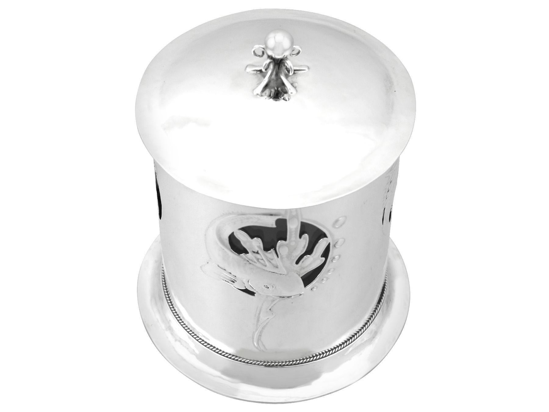 An exceptional, fine and impressive antique English sterling silver and glass biscuit box in the Arts and Crafts style; an addition to our diverse silver box collection.

This exceptional antique Edwardian sterling silver and glass biscuit box has