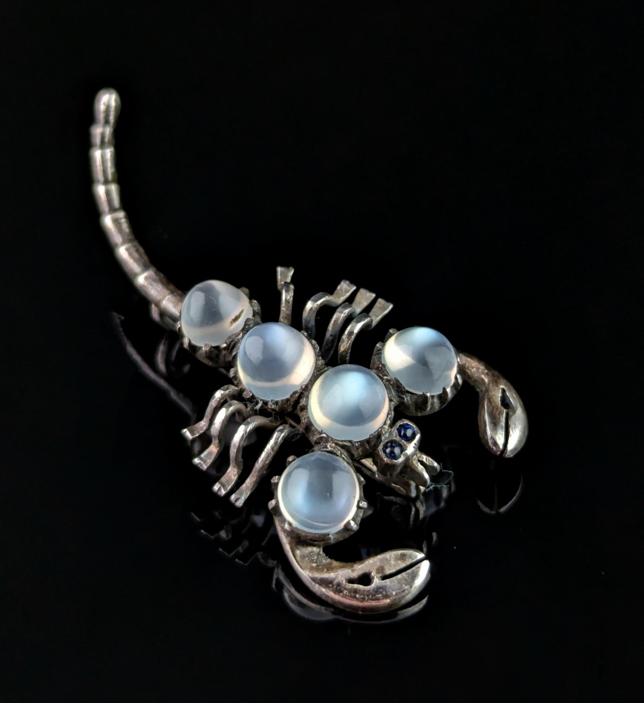 A gorgeous and mystical antique, sterling silver and Moonstone scorpion brooch.

The scorpion body is crafted from cool sterling silver, and has an outstretched tail and claws.

The top of the body adorned with large Moonstone cabochons with a