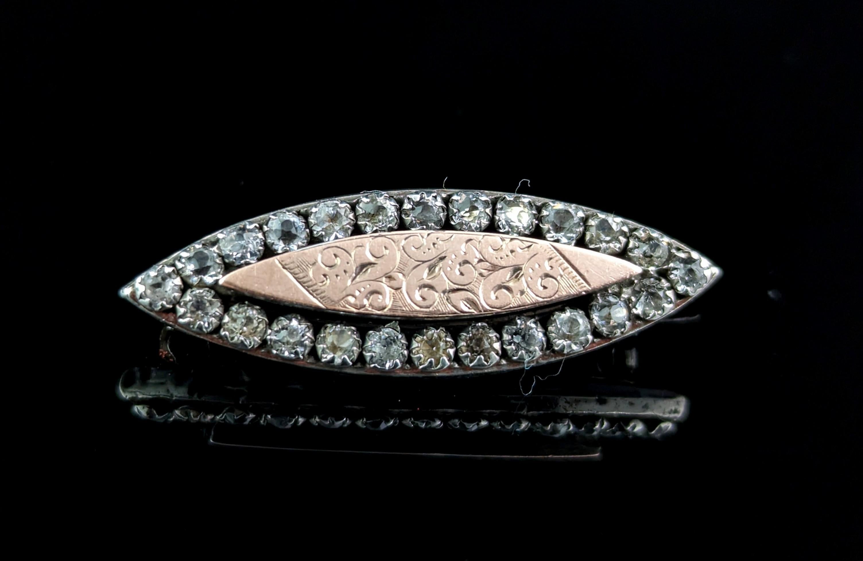 A pretty Victorian silver, paste and Rose gold brooch.

It is an ellipse shaped brooch with a beautiful rim of sparkling paste stones, the centre has an applied rose gold panel engraved with a foliate design.

The brooch has an old C type clasp and