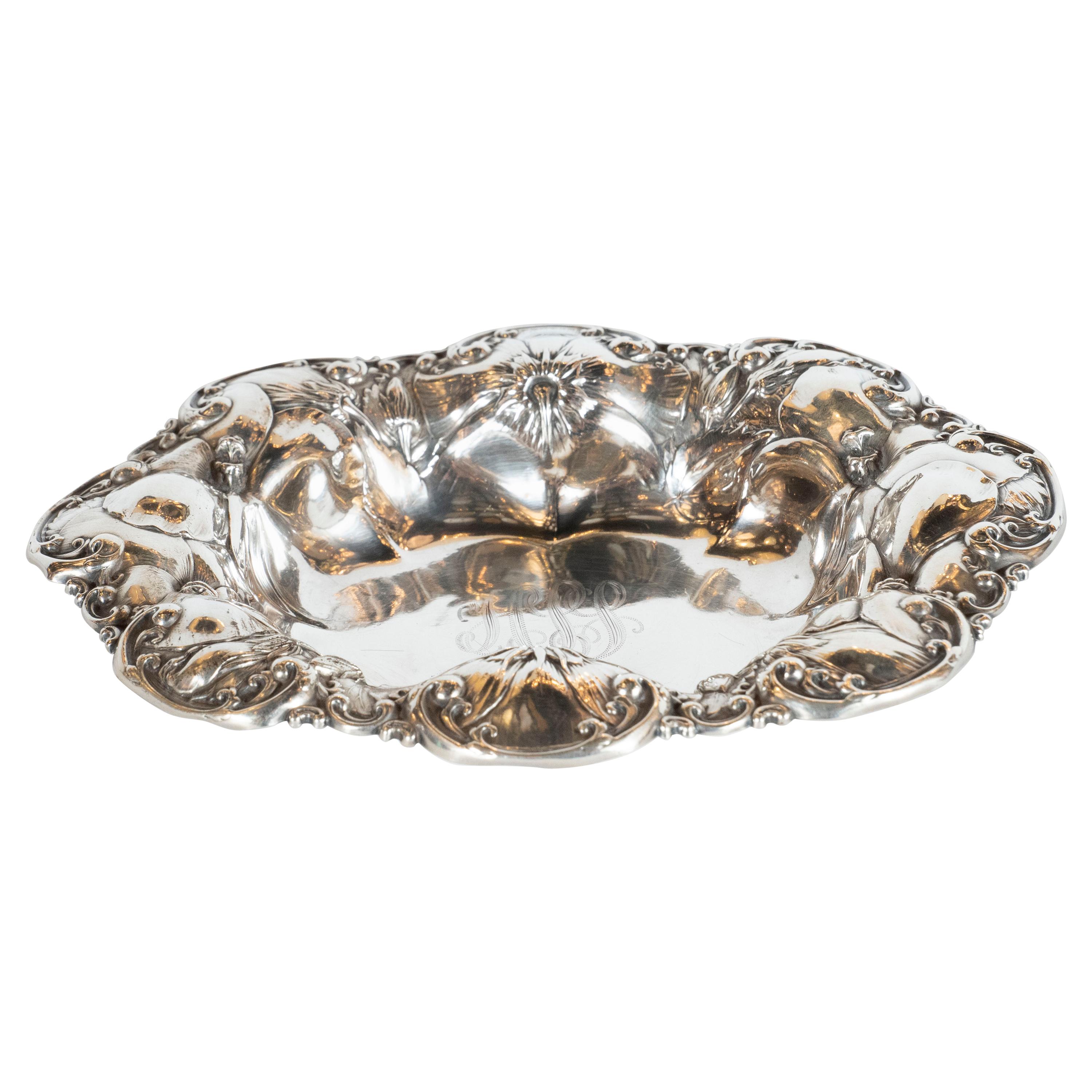 This stunning and sculptural antique decorative bowl was realized in England, circa 1900. It features a scalloped border with an abundance of stylized morning glory flowers at different stages of blooming. The floral forms are overlaid on top of one
