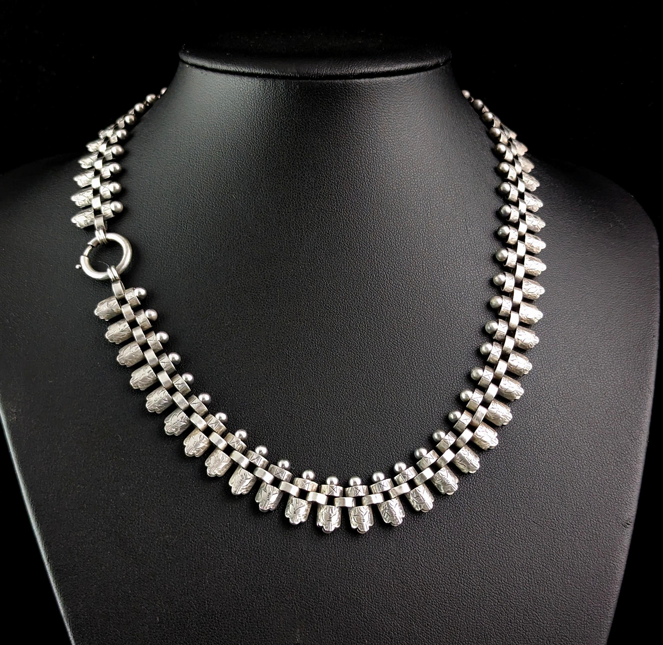 You can't help but be charmed by this elaborate antique, Victorian era sterling silver collar necklace.

This is one of the more pretty examples and there is so much detailing on this piece.

It has fancy engraved links interlocking with silver