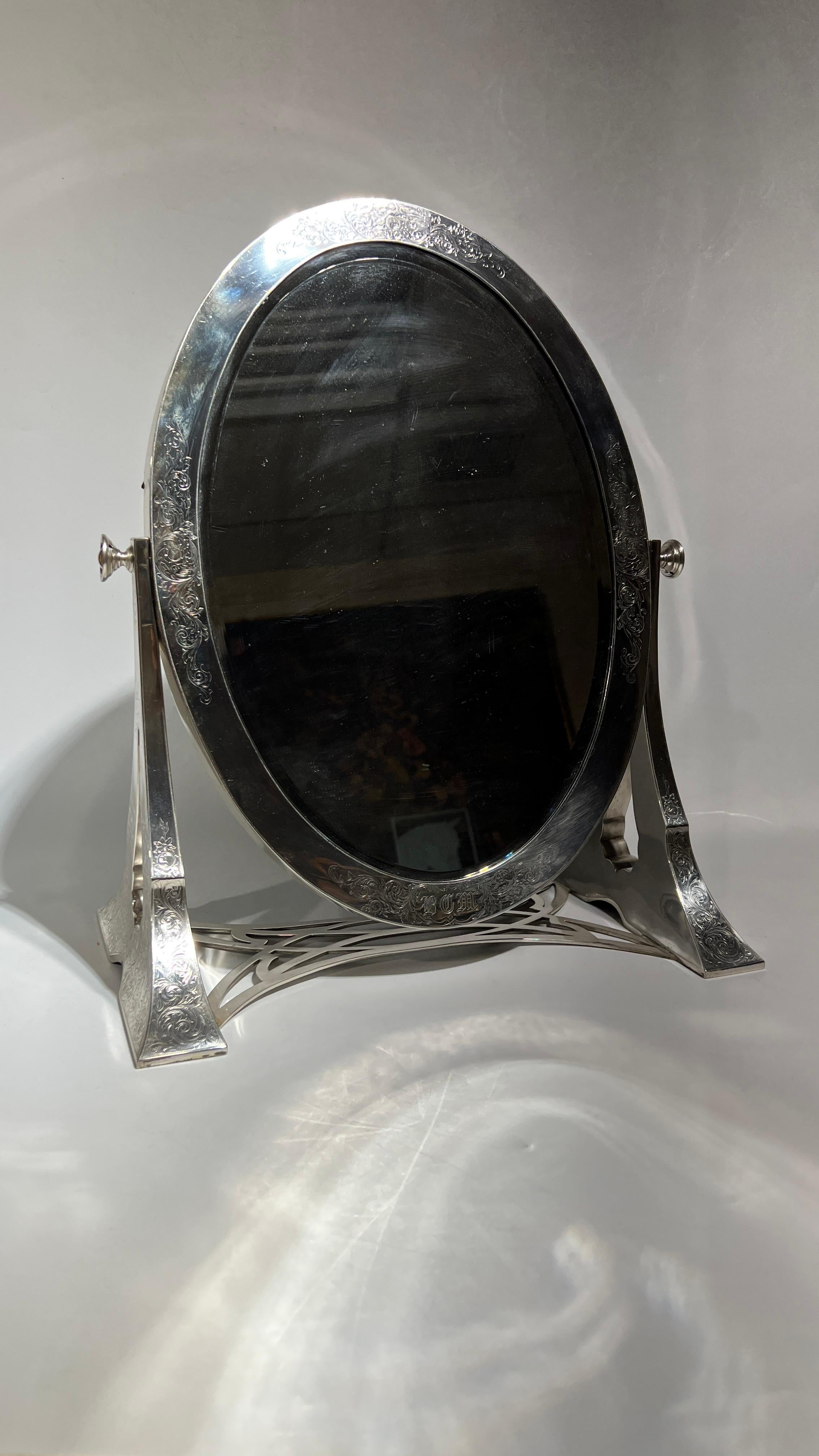Beautiful and large, antique dressing mirror in sterling silver retailed by the Grogan Company of Pittsburgh, active 1890-1930.  Apparently with original mirror and original felt covered rear panel, in very good condition, currently with a high