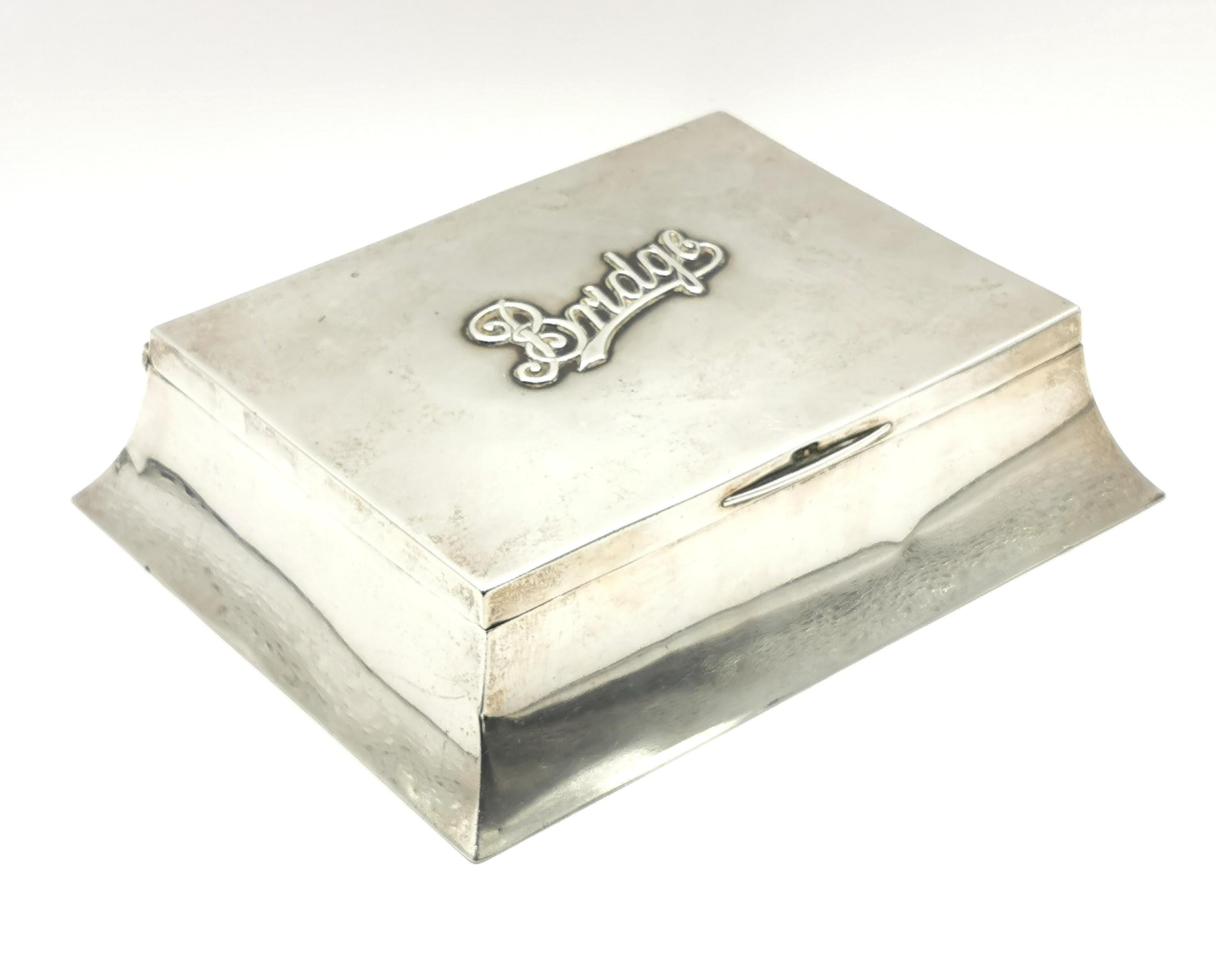 A very fine and large Antique sterling silver bridge box or playing card box.

It is a good size and lined with cedar wood with space for two decks of cards, it has sloped canted sides and embossed silver lettering to the top which reads