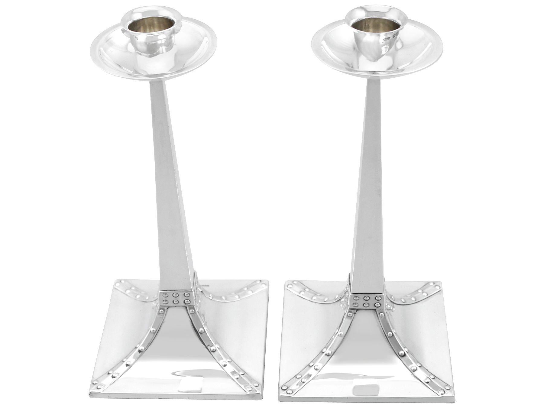 These exceptional antique Edwardian English sterling silver candlesticks have a plain square form in the classic Arts and Crafts style.


The plain hallmarked waisted cylindrical capitals of these antique silver candlesticks surmount circular