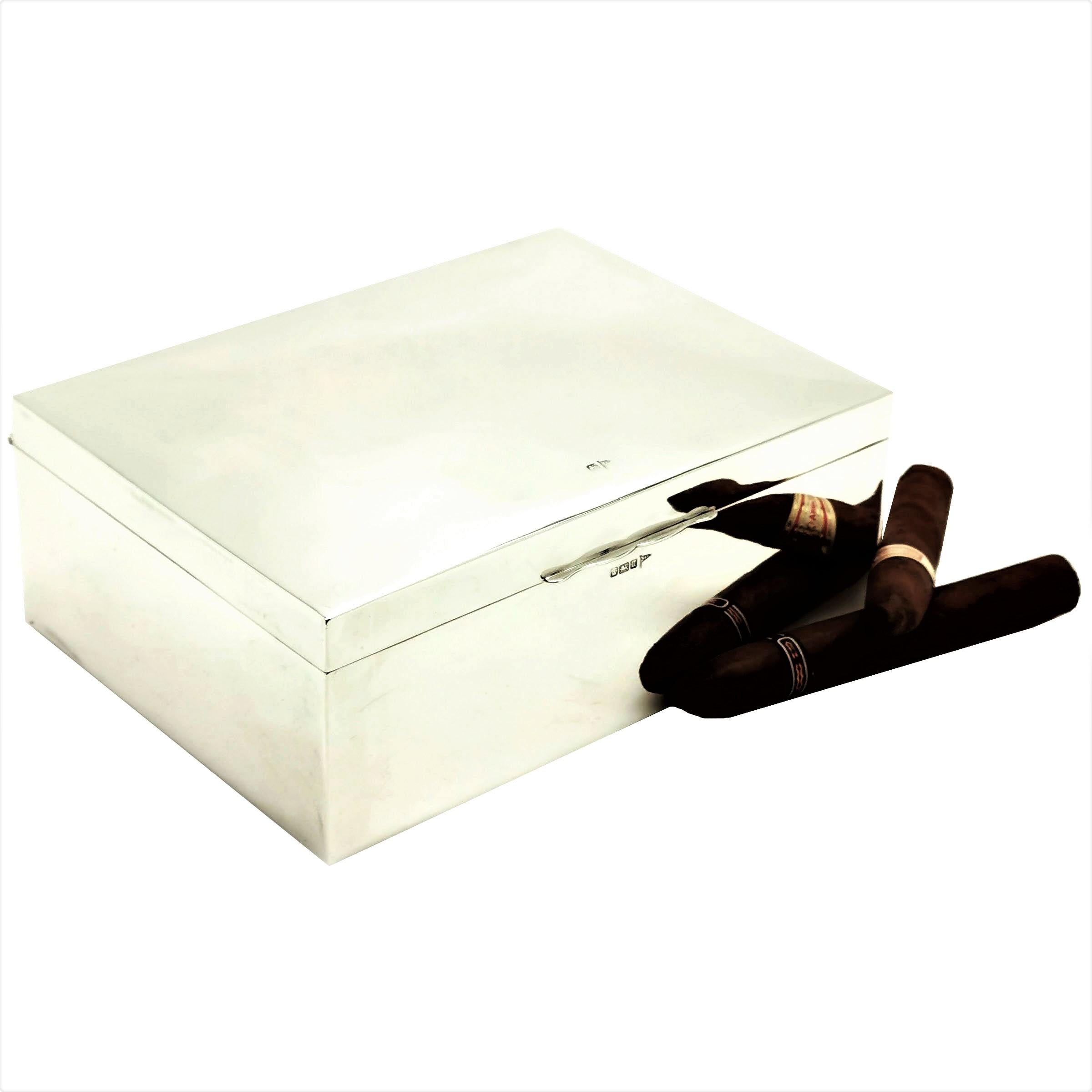 Une boîte à cigares classique en argent massif antique avec un extérieur en argent hautement poli. L'intérieur de la boîte d'argent a une base doublée de bois de cèdre et le couvercle est doré. L'intérieur est équipé d'une cloison en bois