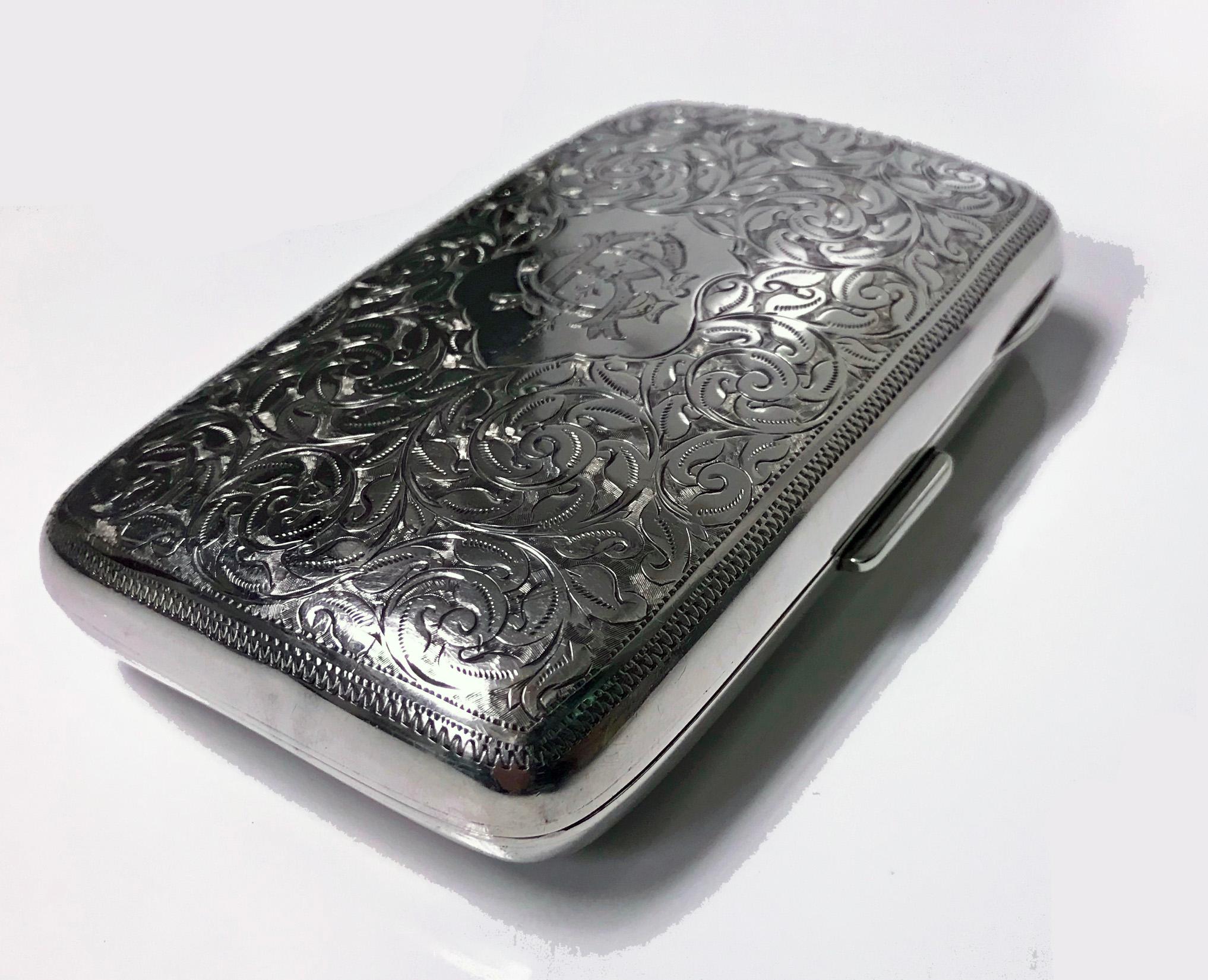 Antique sterling silver cigarette case, Birmingham 1898 JR. The case of slightly cushion rectangular form richly engraved with foliate decoration, intertwined RC or CR on one side, the interior gilded, original material band, has some wear to