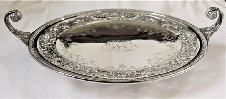 This ornately engraved sterling silver centerpiece was made by the Mount Vernon Co. of the United States in approximately 1915 in a Neoclassical Revival style. This large and shallow handled bowl or dish has a nicely executed band with a leaf and