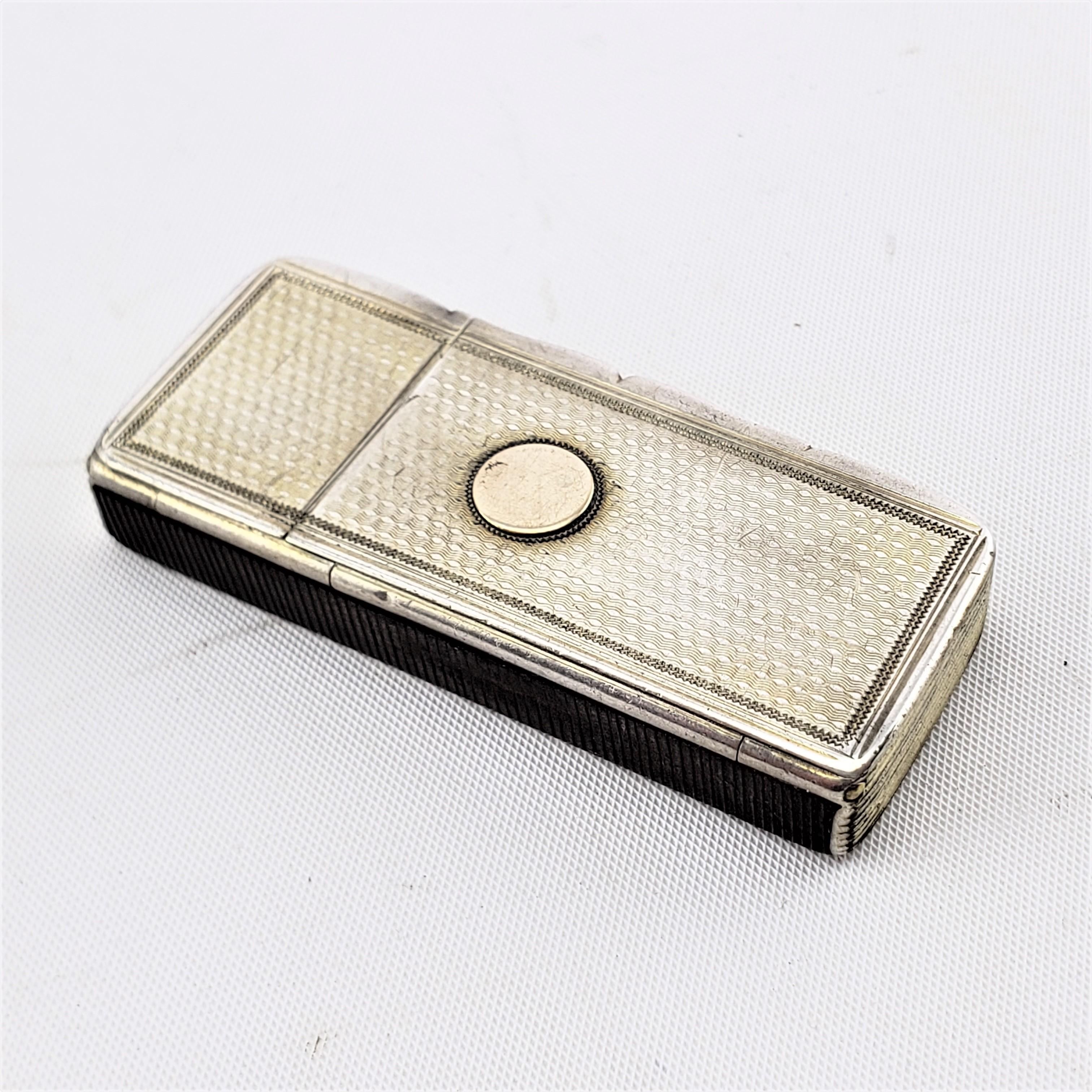 This antique double compartment snuff box is hallmarked by an unknown maker, and originated from England, dating to approximately 1900 and done in a period Edwardian style. The box is composed of sterling silver and has two hinged lids with an