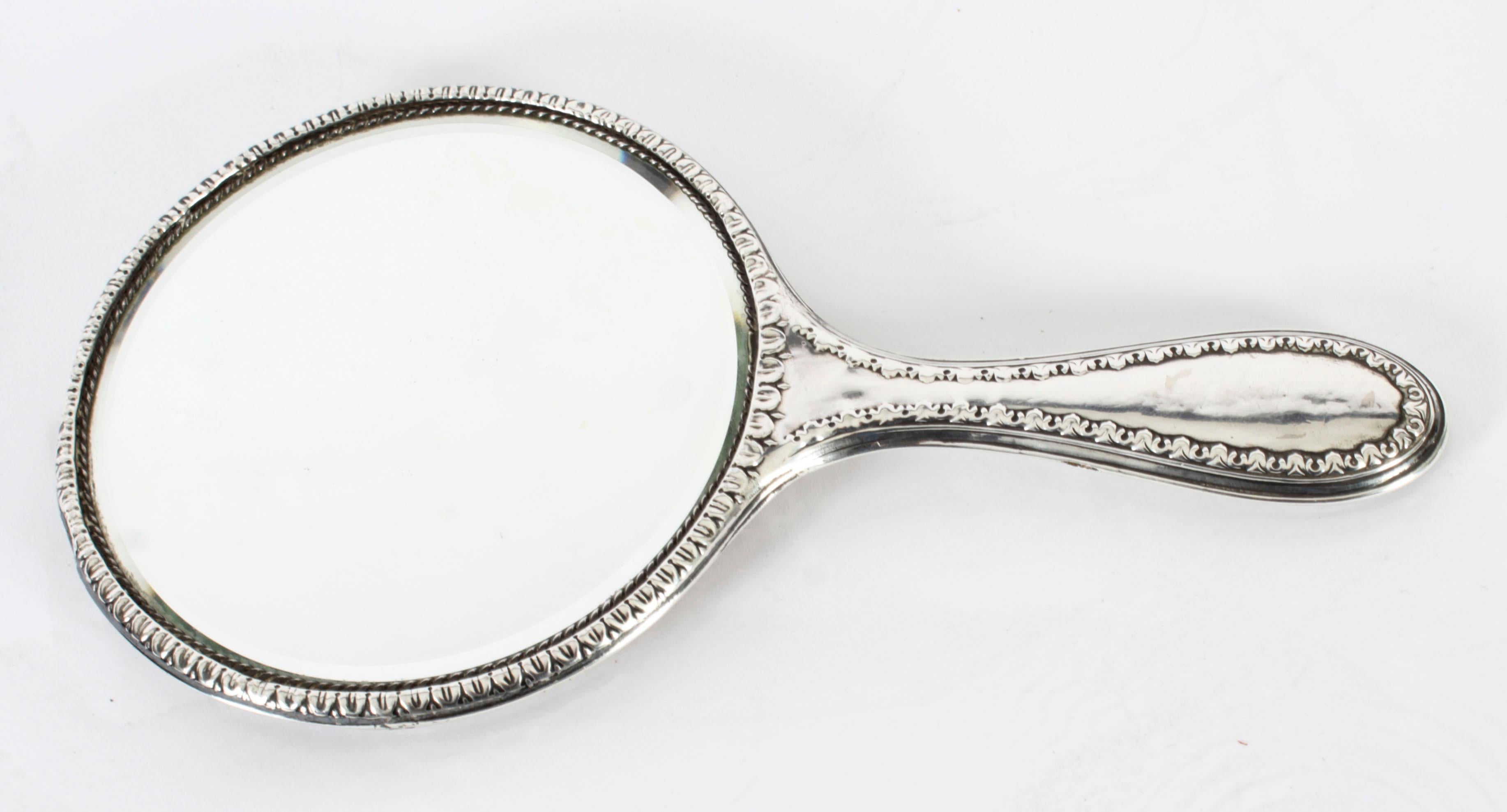 This is a wonderful antique George V sterling silver hand-mirror with hallmarks for Birmingham 1916 and the maker's mark of the renowned silversmiths H Matthews.
 
The vanity bevelled mirror features a heavy embossed solid silver decoration in the