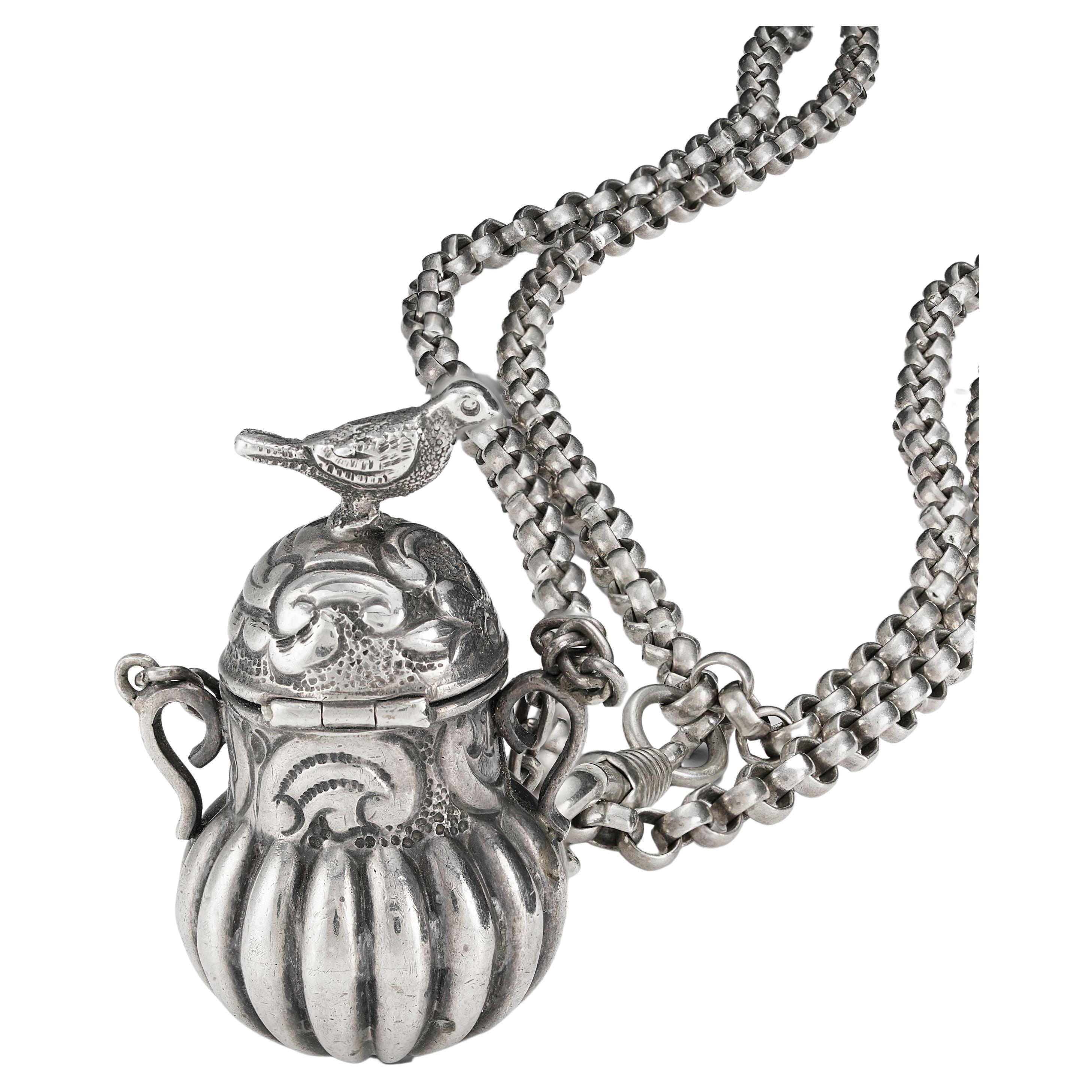 Simply Fabulous and Rare! Beautifully Hand crafted and engraved Sterling Silver Vinaigrette Pendant. Modeled as a Vessel topped with a Bird finial. The hinged Lid opens to reveal a Gilded pierced grill with intricate scroll filigree design.