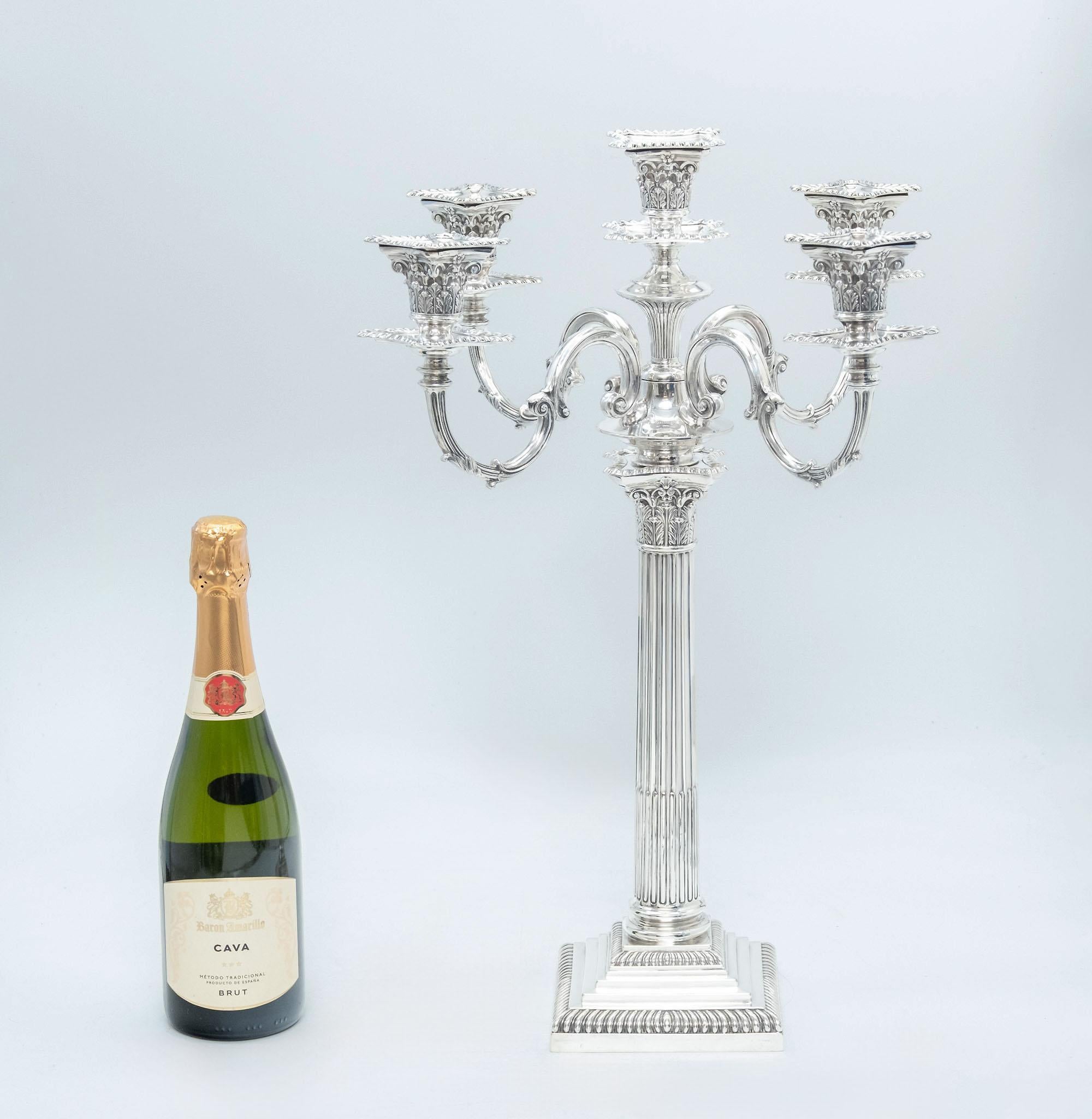 Un imponente candelabro antico di Giorgio V in argento sterling a cinque luci con colonna corinzia. Completamente marchiato Goldsmiths & Silversmiths & Co, Londra nel 1925.

Di forma neoclassica, ha una base quadrata a gradini con una colonna