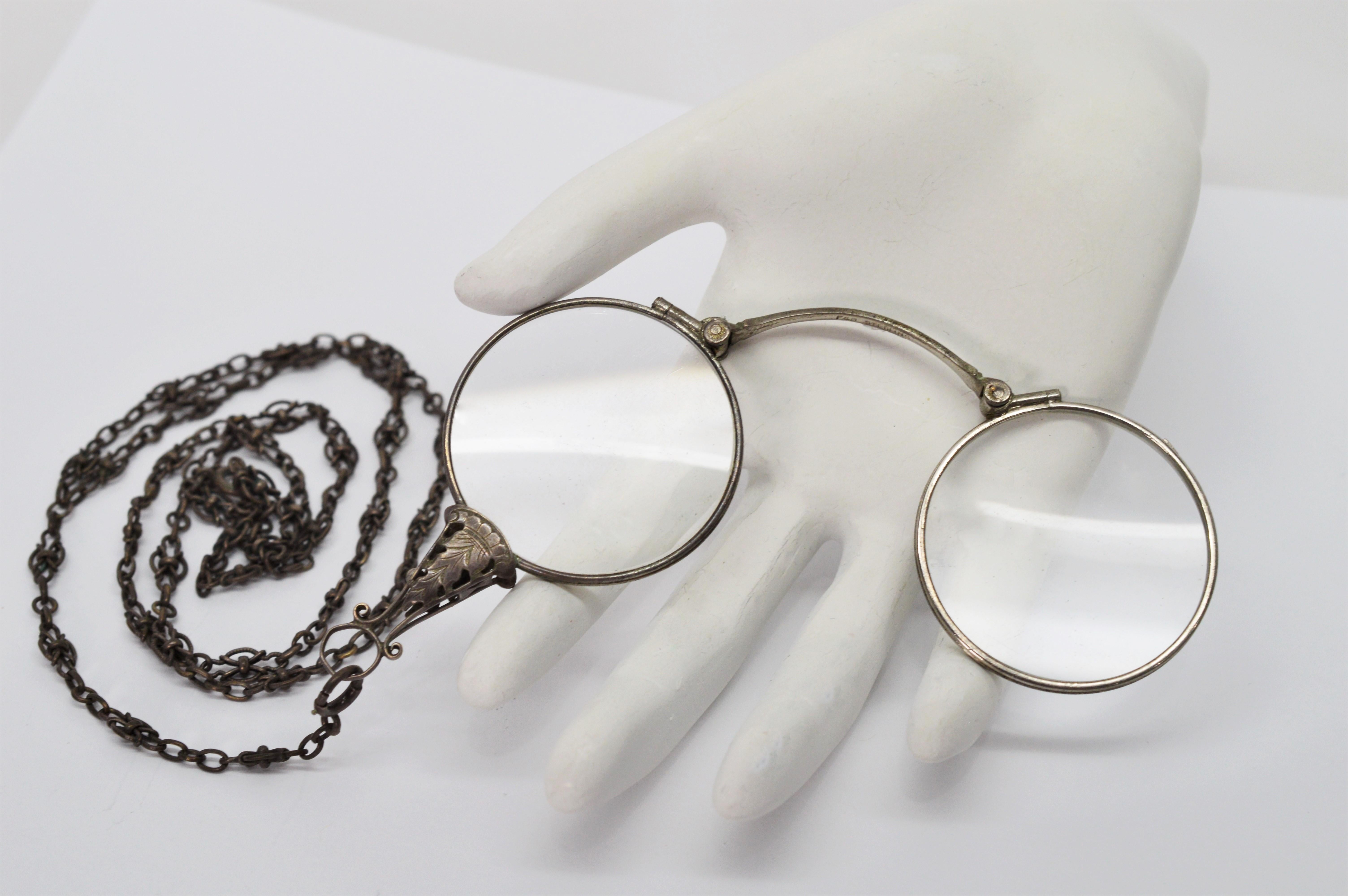Antique Lorgnette Opera Glasses with sterling silver frames, chain and silver filigree stem with an engraved leaf design. The thirty inch chain is finished with a spring ring closure. This collectible piece has the original lenses measuring 1-3/8