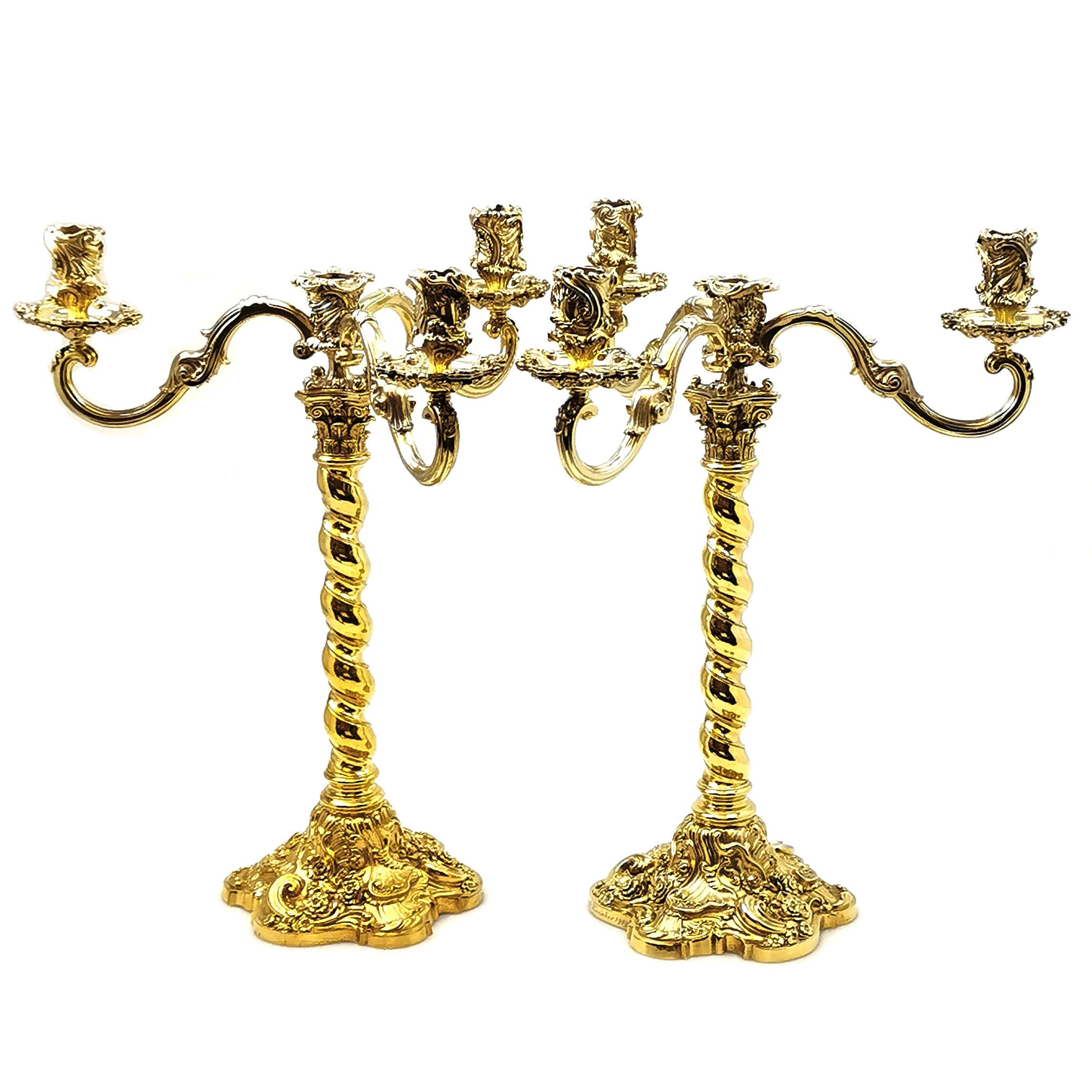 A magnificent pair of Antique Silver Gilt Candelabra. These Candelabra stand on impressive chased bases featuring Rococo style shell, scroll and floral patterning. The Candlesticks have a barley twist column with a Corinthian Capital. The Candelabra