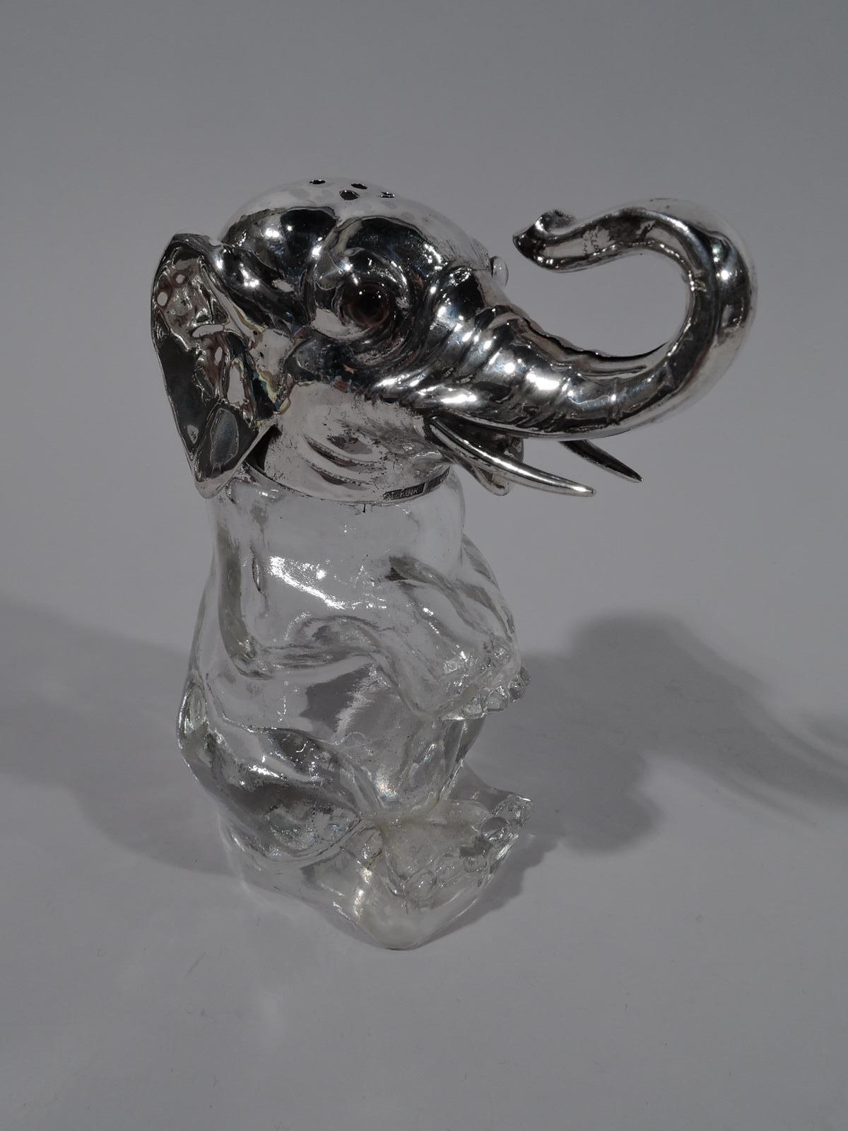Antique sterling silver and clear glass sugar caster, circa 1910. Body in clear glass and head in sterling silver. Elephant is seated with straight hind legs and dangling forelegs. Ears are flapped back and trunk is turned up. Fine details,