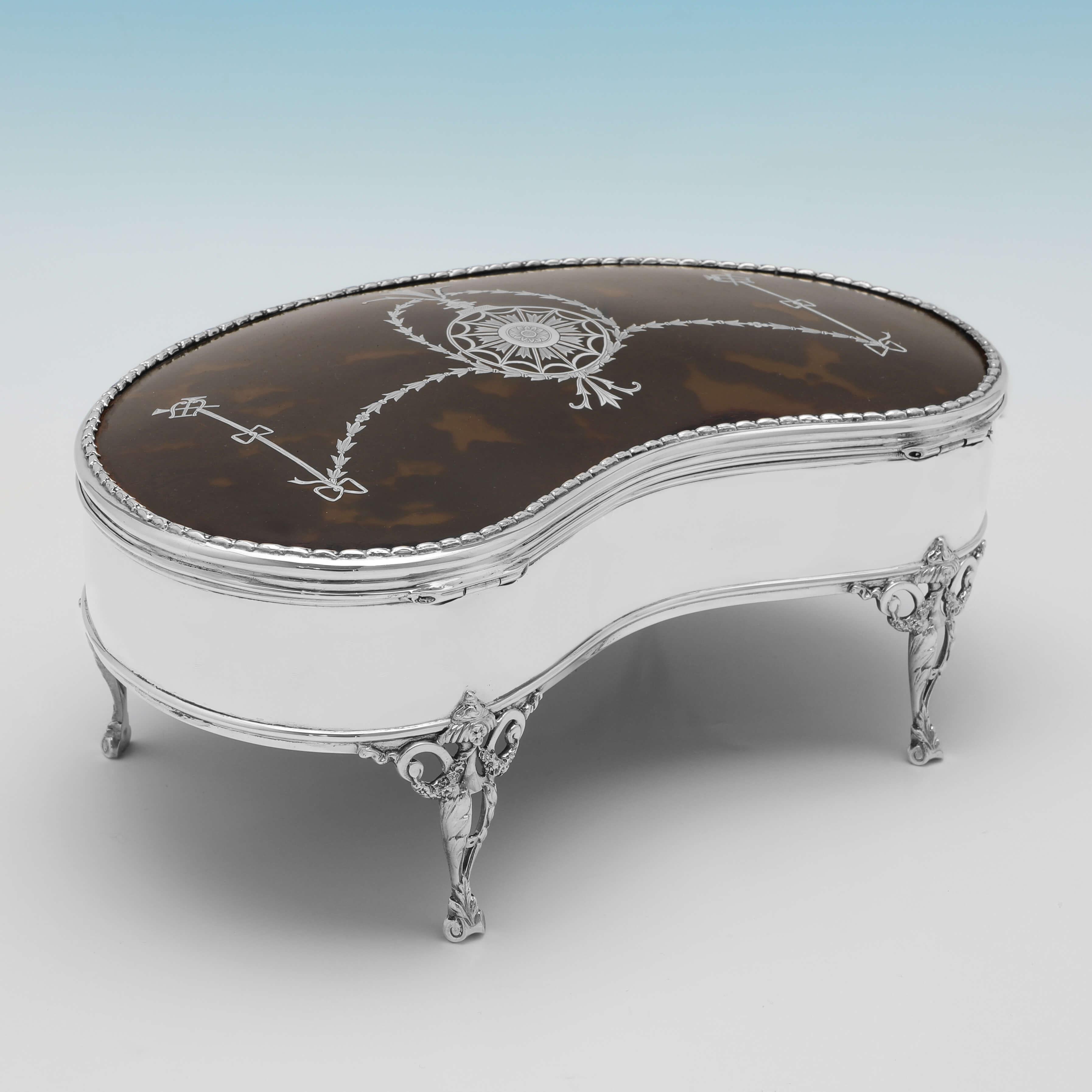 Hallmarked in London in 1911 by William Comyns, this attractive, Antique Sterling Silver Jewellery Box, is kidney shaped, and features a tortoiseshell lid with silver inlay, 4 neoclassical legs, and a lined interior. 

The jewellery box measures