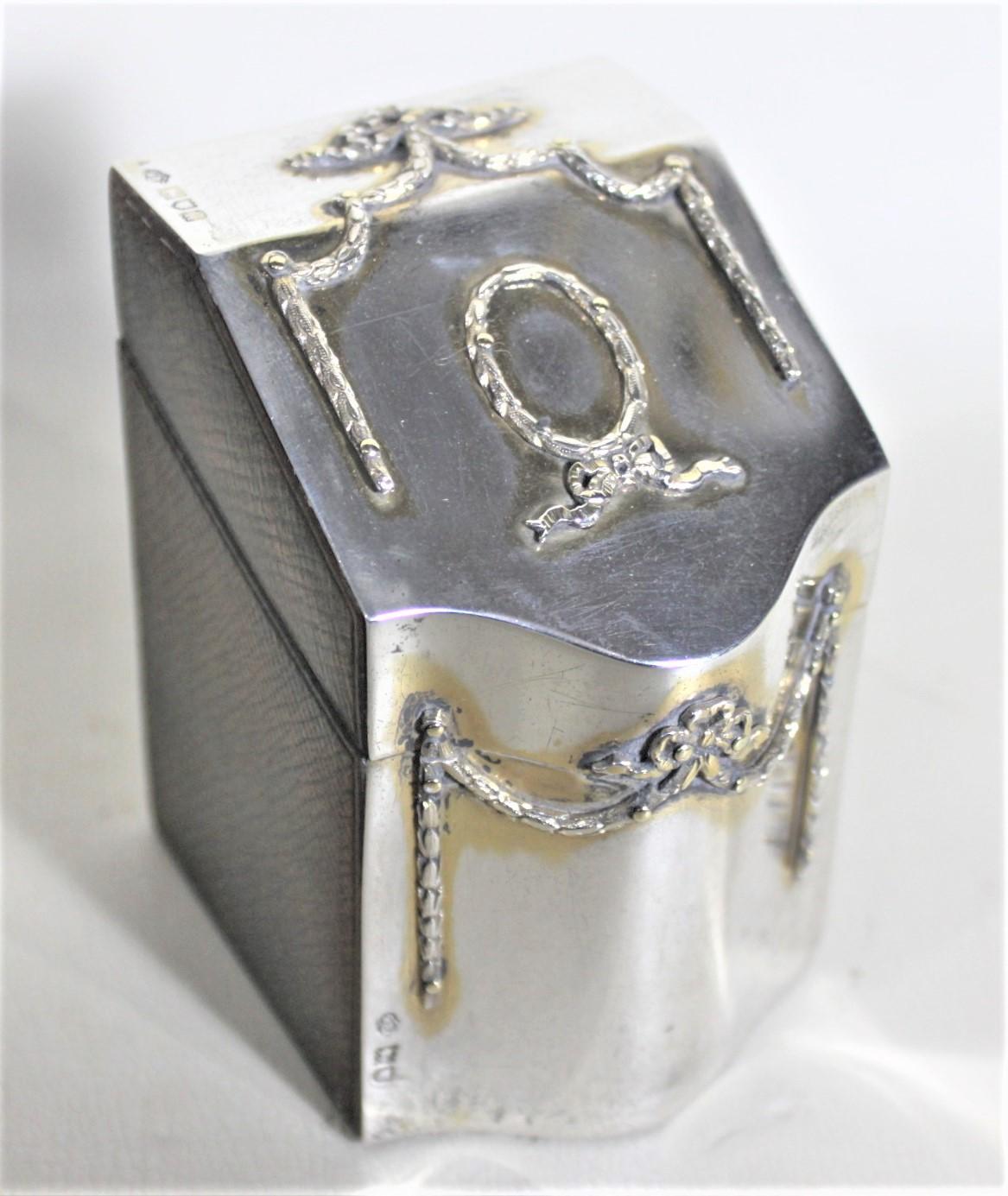 This antique sterling silver and leather playing card box was made in London, England is 1885 by an unknown maker, in a period Victorian style. The box is styled as a miniature knife box with a hinged top and partition in the bottom making two