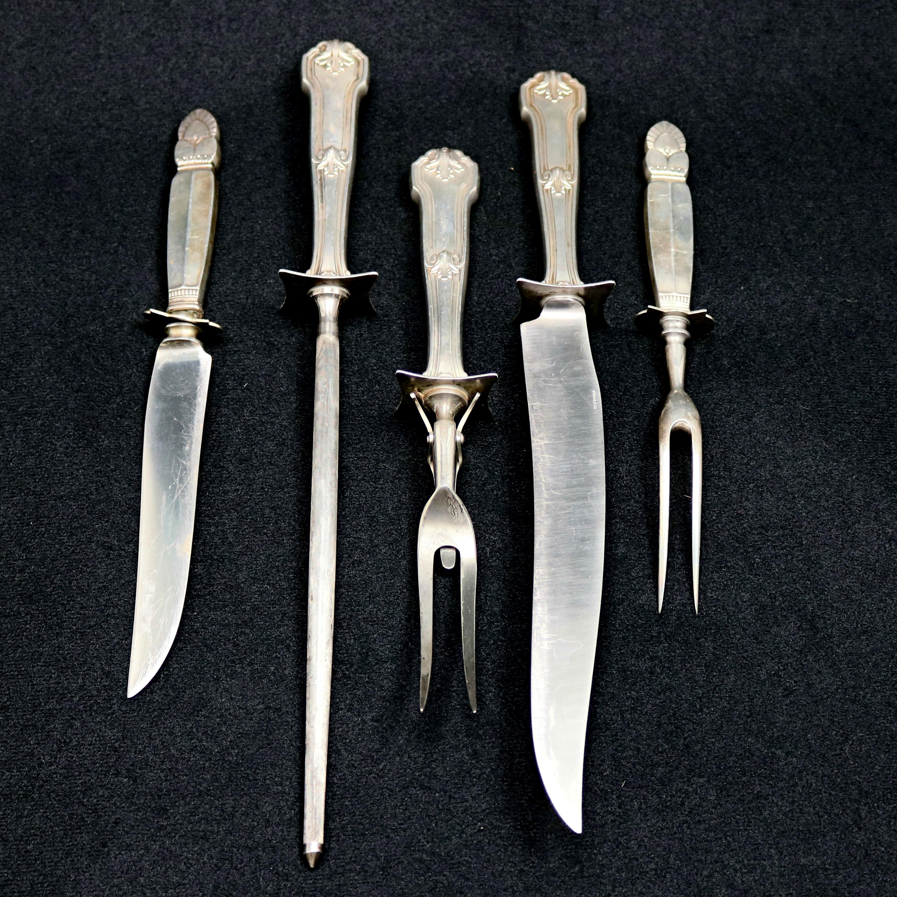 Two antique sterling silver meat carving sets offer decorated handles and, in total, include two meat forks, two carving knives and a blade sharpening rod, three piece set handles are engraved with 