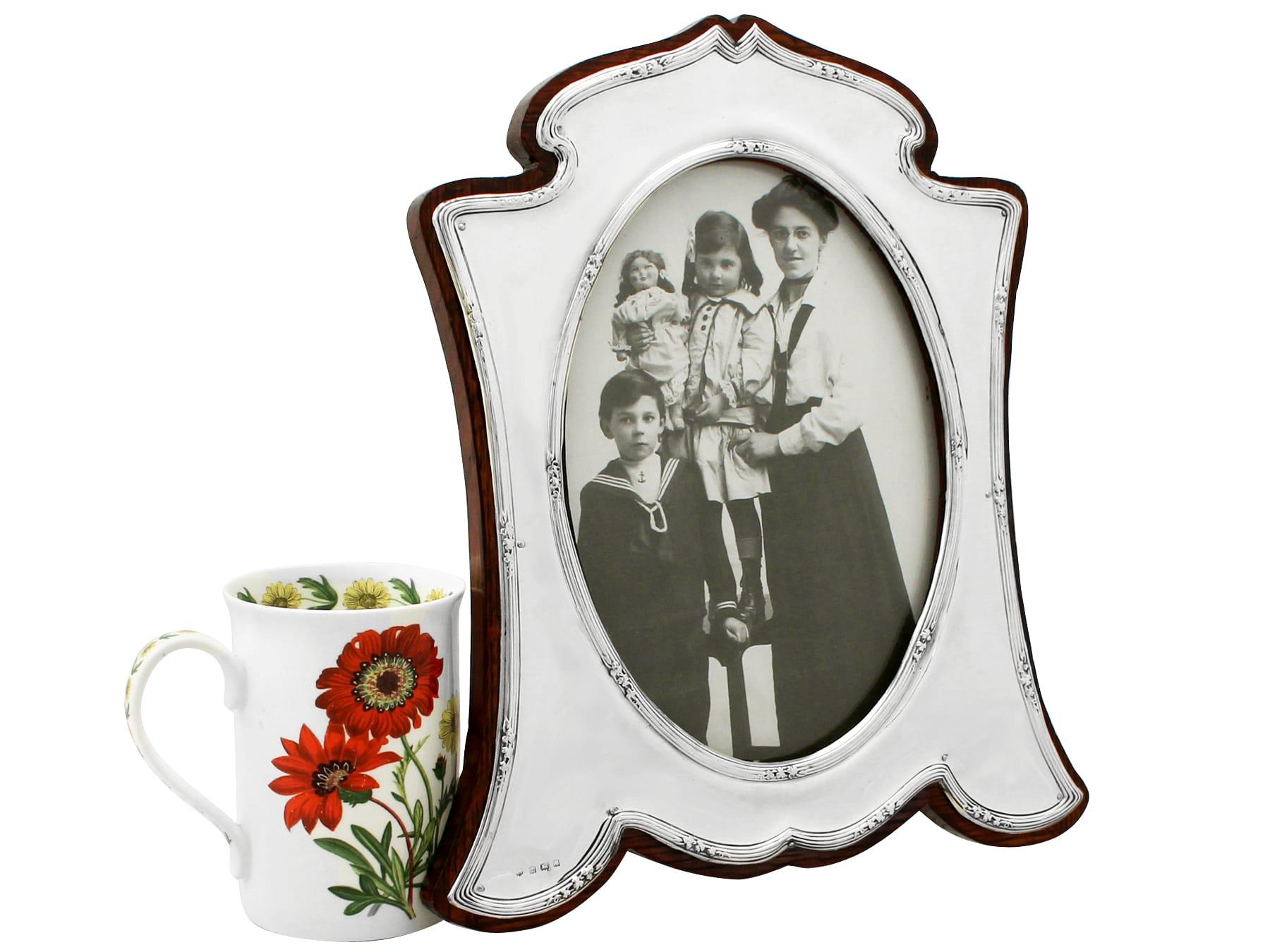 A fine and impressive, large antique George V English sterling silver photograph frame; an addition to our ornamental silverware collection.

This fine antique George V sterling silver photograph frame has a waisted arabesque style shaped form with