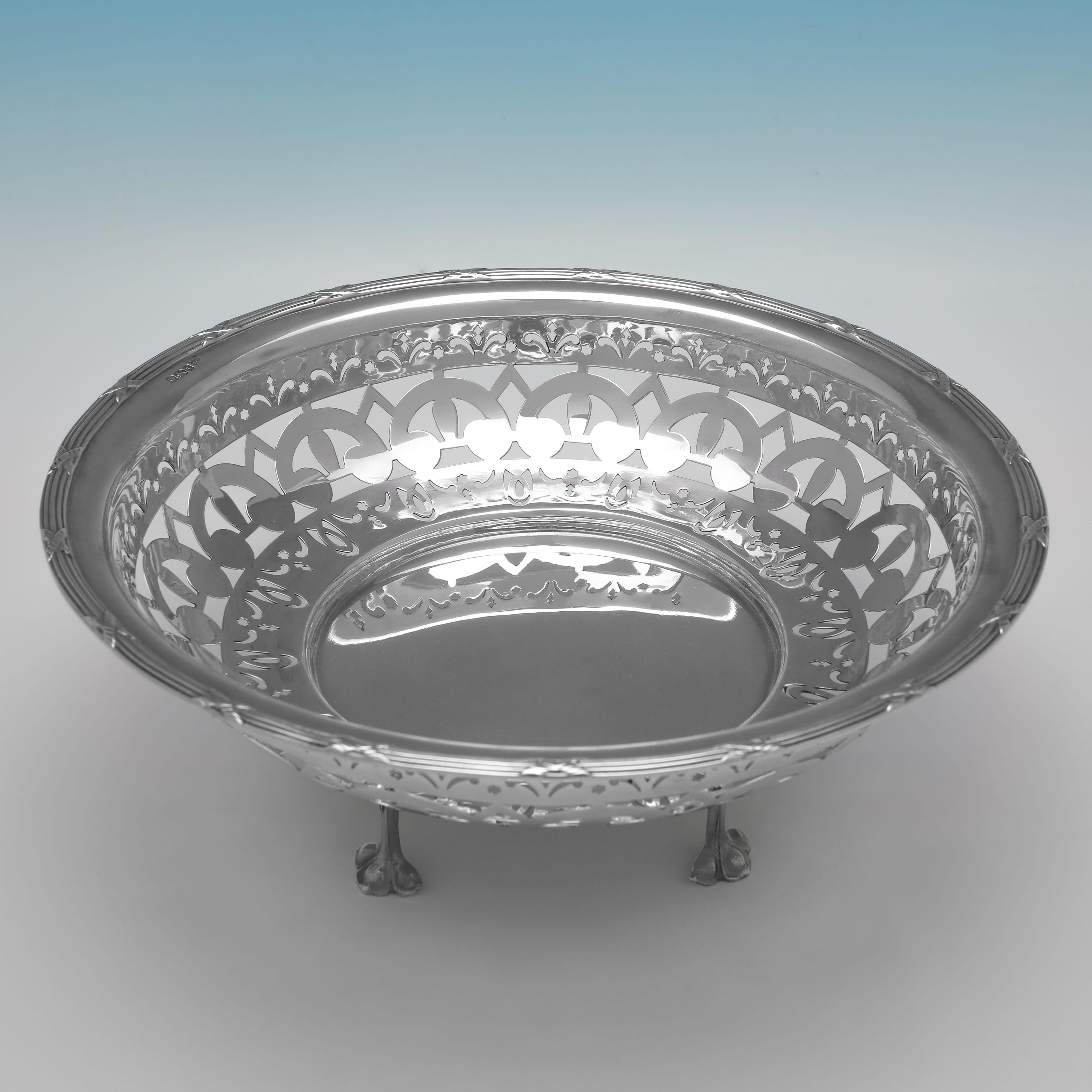 Matriculado en Sheffield en 1911 por Walker & Hall, este atractivo Plato Antiguo de Plata de Ley tiene forma redonda, decoración calada y pies de fundición. El plato mide 10 cm de alto por 25,5 cm de diámetro y pesa 14,9 onzas troy.