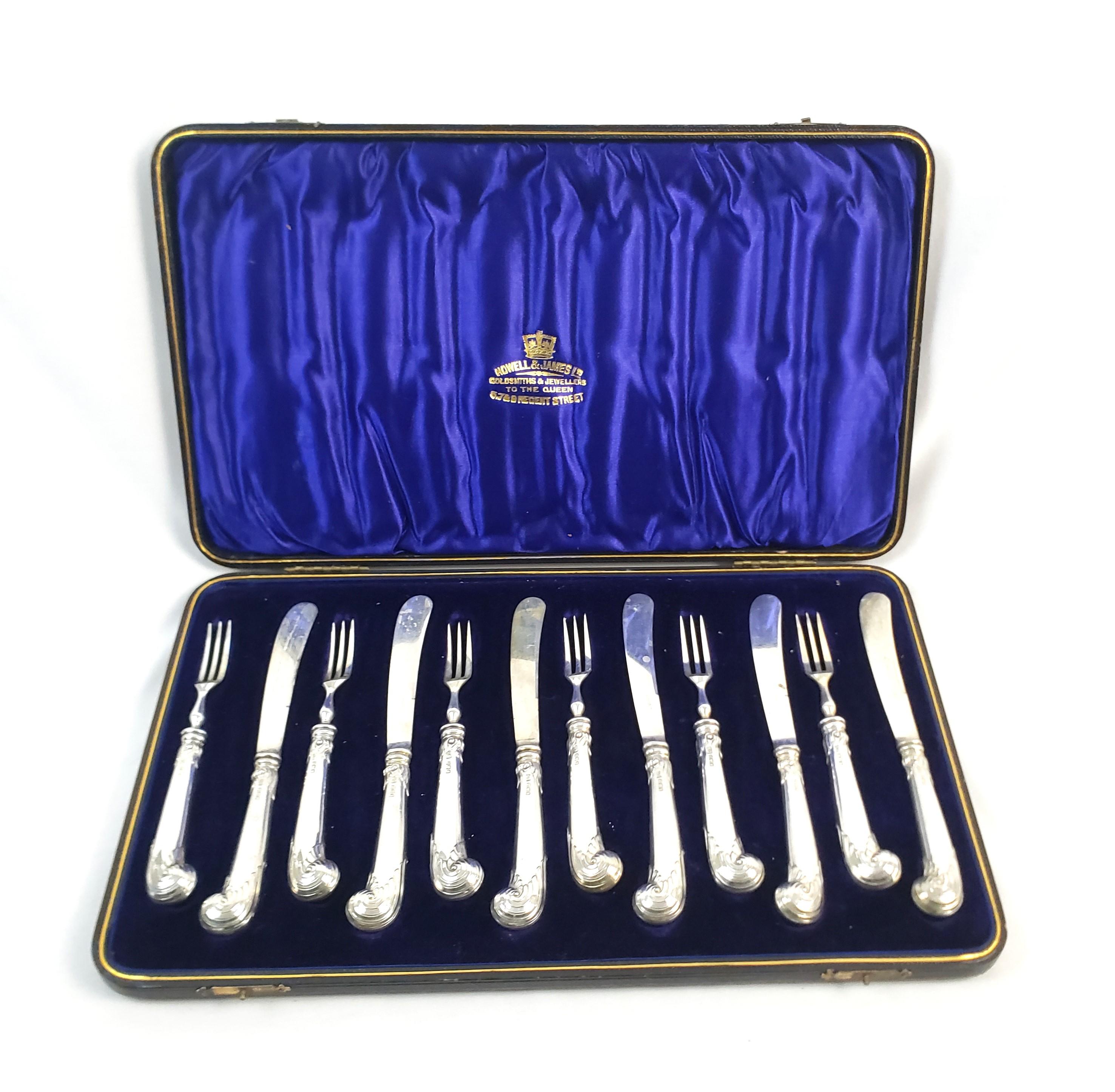 This antique sterling silver boxed desert knife and fork set is hallmarked by an unknown maker, but originated from England and dates to approximately 1910 and  done in the period Edwarian style. The handles of the set are composed of sterling