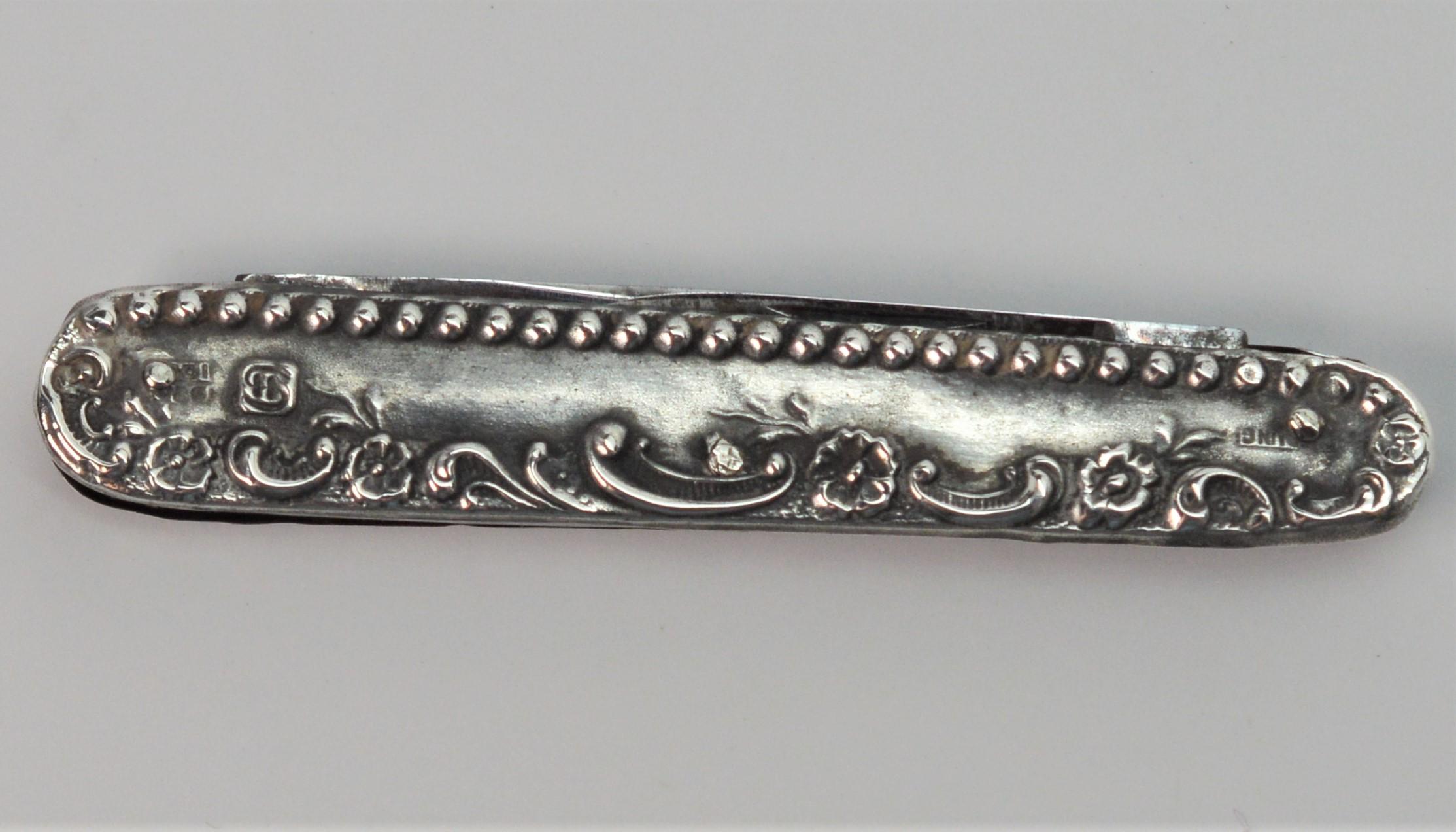 In its original condition, this 2-1/4 inch Gentleman's Antique Sterling Silver Pocket Knife has two small folding steel blades including a one inch blade and a three-quarter inch blade. Has unknown hallmarks and is signed 