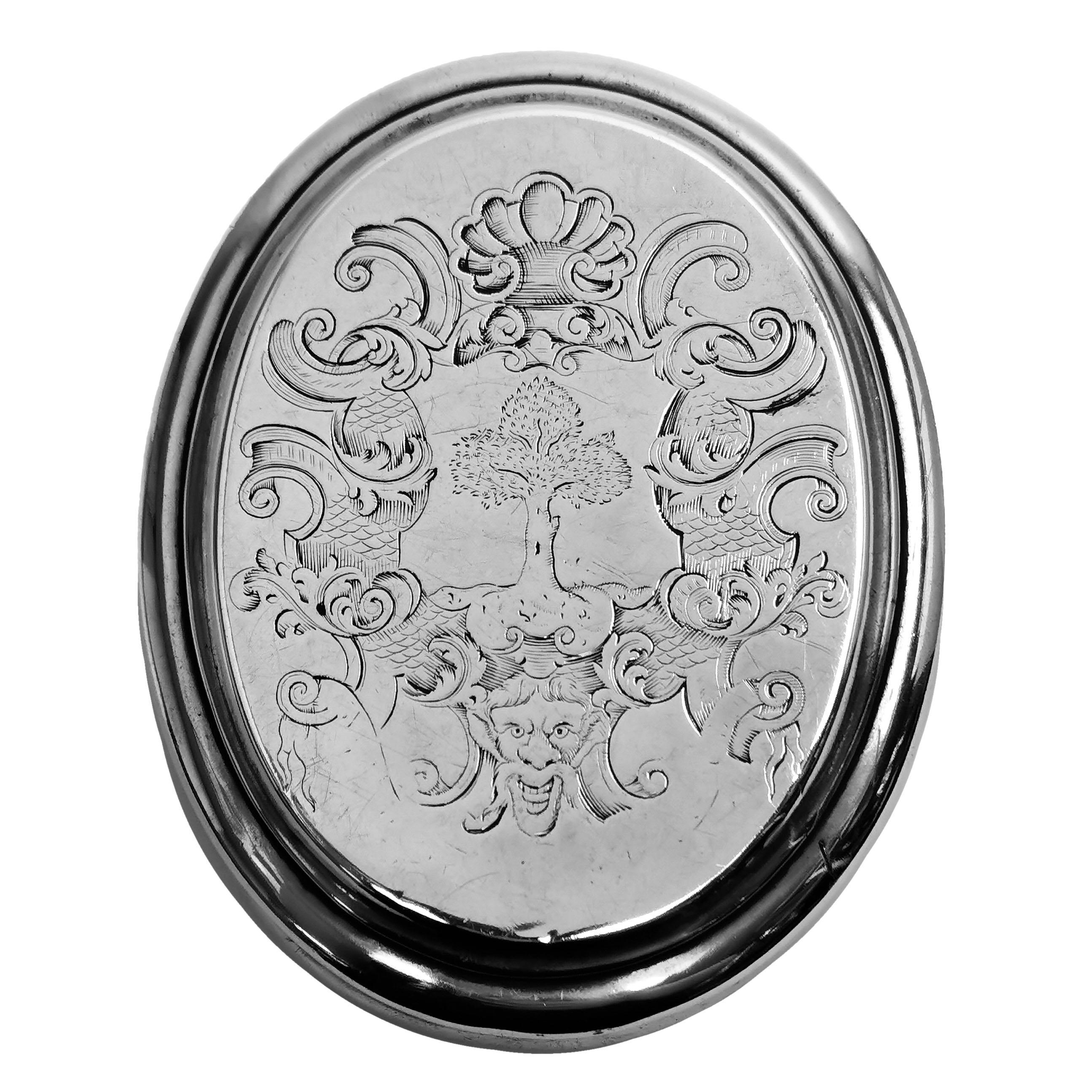 A beautiful antique Queen Anne solid silver tobacco box with a classic oval form. The fitted lid has an intricate engraved armorial, and the interior is gilded.

Made in London, England in 1711 by Edward Cornock

Weight - 130g
Length -